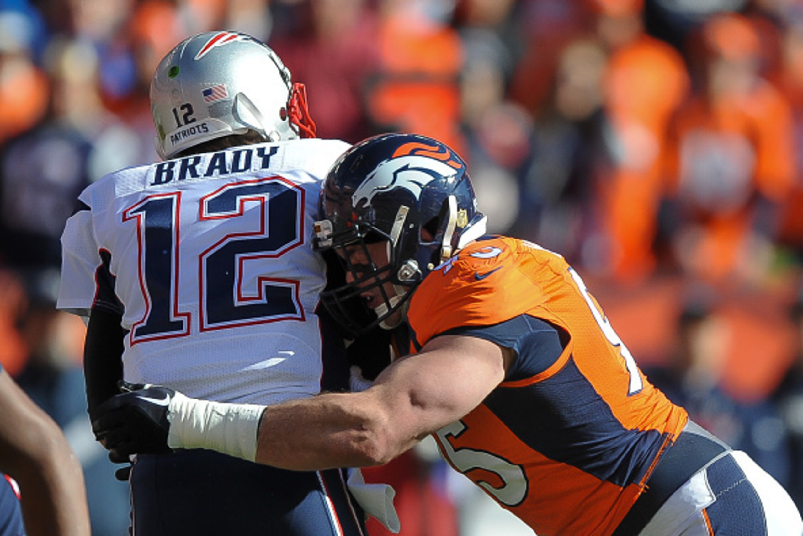 DENVER, CO - JANUARY 24:  Tom Brady #12 of the New England Patriots his hit by Derek Wolfe #95 of the Denver Broncos  in the AFC Championship game at Sports Authority Field at Mile High on January 24, 2016 in Denver, Colorado.  (Photo by Dustin Bradford/G