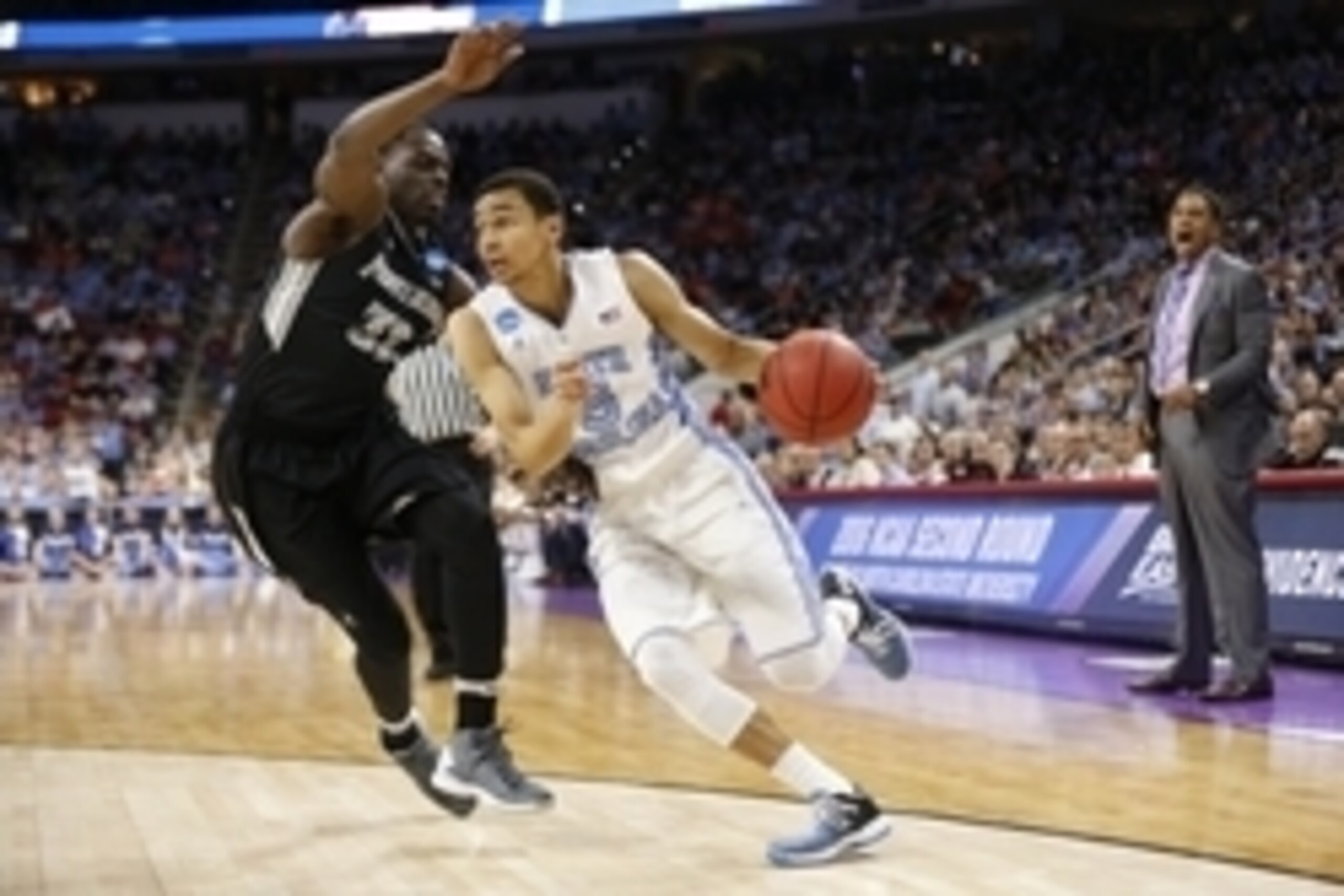 Mar 19, 2016; Raleigh, NC, USA; North Carolina Tar Heels guard Marcus Paige (5) dribbles the ball around Providence Friars guard Junior Lomomba (32) in the first half during the second round of the 2016 NCAA Tournament at PNC Arena. Mandatory Credit: Geof