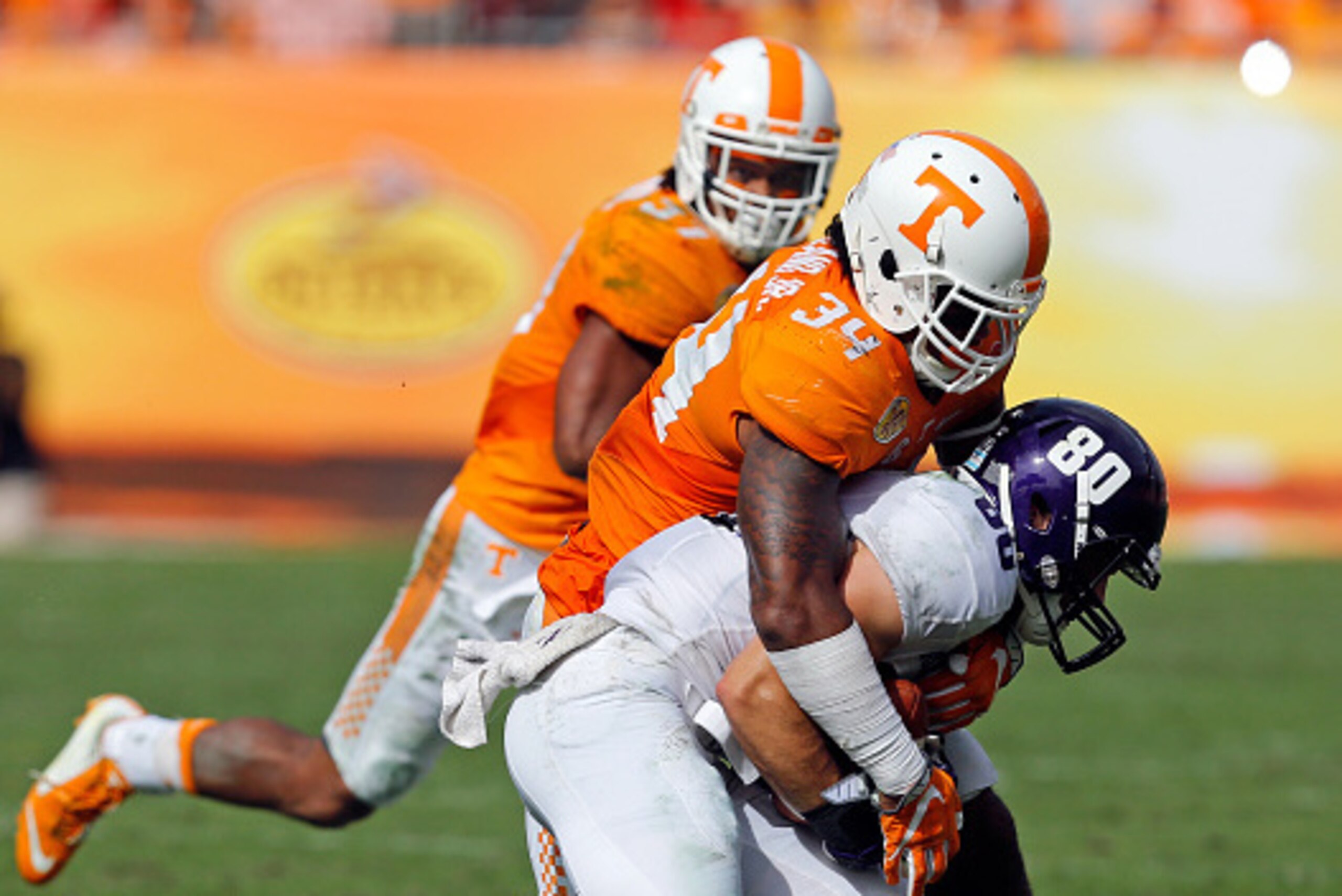 TAMPA, FL - JANUARY 1:  Austin Carr #80 of the Northwestern Wildcats is tackled by Darrin Kirkland Jr. #34 of the Tennessee Volunteers during the Outback Bowl at Raymond James Stadium on January 1, 2016 in Tampa, Florida. (Photo by Mike Carlson/Getty Imag