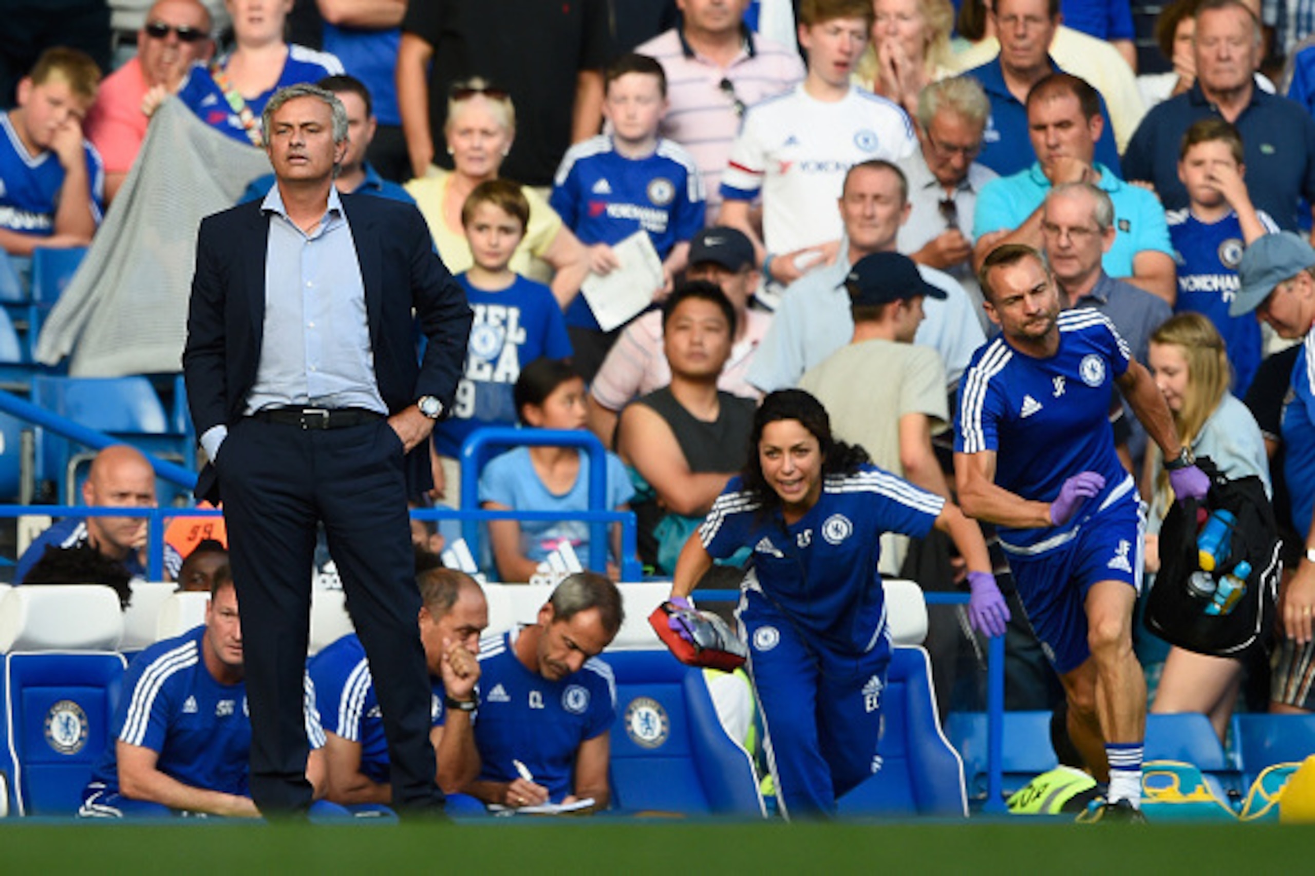 LONDON, ENGLAND - AUGUST 08:  Chelsea manager Jose Mourinho looks on as team doctor Eva Carneiro rushes to treat Eden Hazard during the Barclays Premier League match between Chelsea and Swansea City at Stamford Bridge on August 8, 2015 in London, England.