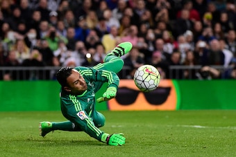 Real Madrid's Costa Rican goalkeeper Keylor Navas stops a penalty  during the Spanish league football match Real Madrid CF vs Sevilla FC at the Santiago Bernabeu stadium in Madrid on March 20, 2016. / AFP / PIERRE-PHILIPPE MARCOU        (Photo credit shou