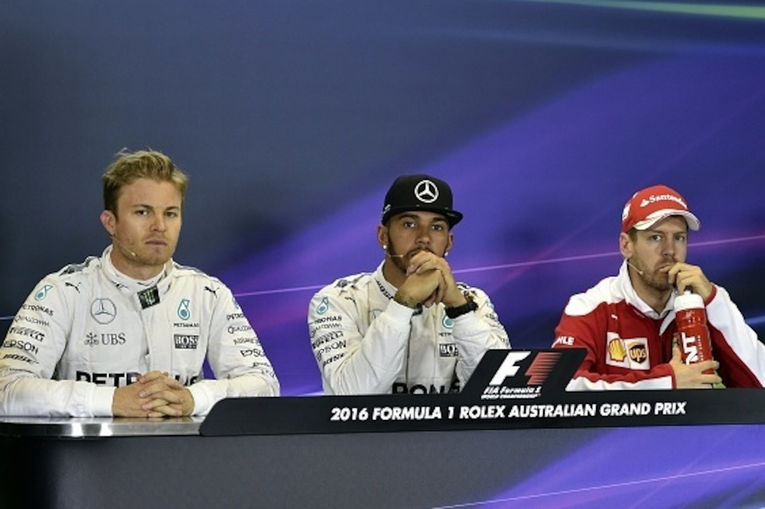 Mercedes AMG Petronas F1 Team's drivers Lewis Hamilton (C) from Britain, teammate Nico Rosberg from Germany (L) and Ferrari's German driver Sebastian Vettel (R) attend a press conference after qualifying for the Formula One Australian Grand Prix in Melbou