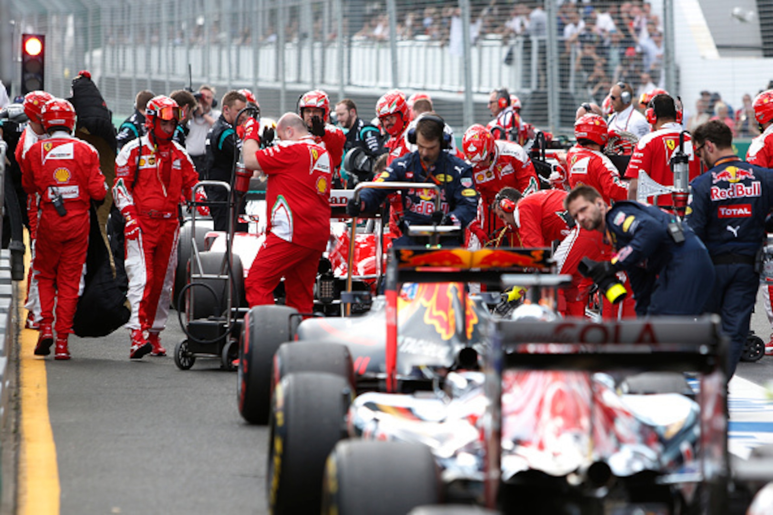 Formula One cars are lined up in the pit lane after the race was temporarily suspended following a crash between McLaren Honda's Spanish driver Fernando Alonso and Haas F1 Team's Brazilian driver Esteban Gutierrez during the Formula One Australian Grand P