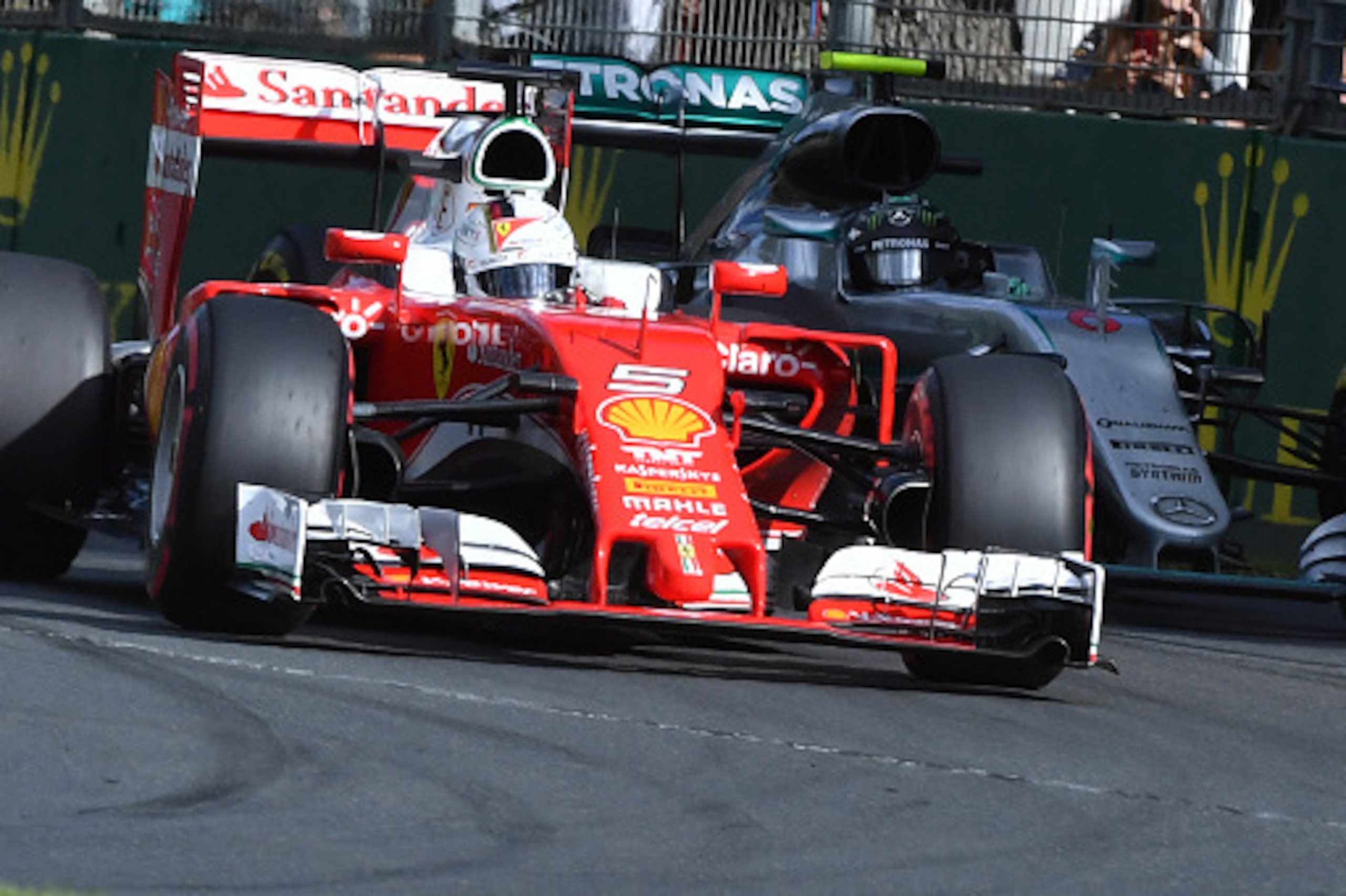 Ferrari's German driver Sebastian Vettel (L) powers through a corner ahead of Mercedes AMG Petronas F1 Team's German driver Nico Rosberg (R) during the Formula One Australian Grand Prix in Melbourne on March 20, 2016.  / AFP / Paul Crock / IMAGE RESTRICTE