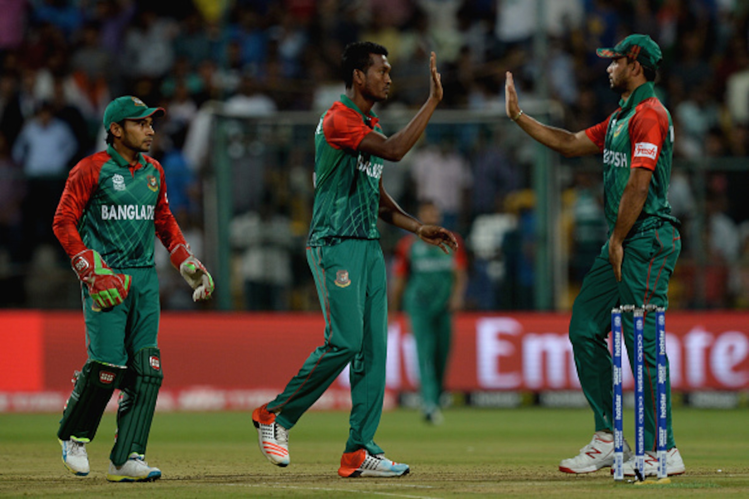 Bangladesh bowler Al-Amin Hossain (C) celebrates with teammates after the dismissal of unseen Indian batsman Suresh Raina during the World T20 cricket tournament match between India and Bangladesh at The Chinnaswamy Stadium in Bangalore on March 23, 2016.