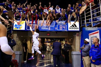 LAWRENCE, KS - JANUARY 30:  Devonte' Graham #4 of the Kansas Jayhawks leaps to high-five fans as he runs off the floor following the Jayhawks 90-84 victory over the Kentucky Wildcats to win the game at Allen Fieldhouse on January 30, 2016 in Lawrence, Kan