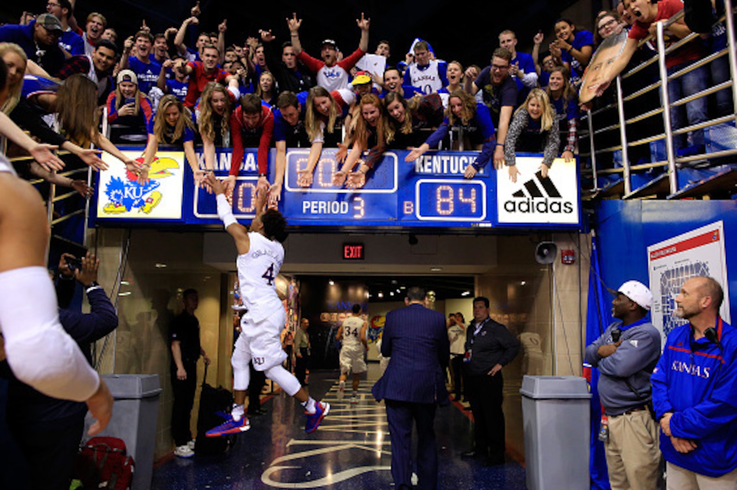 LAWRENCE, KS - JANUARY 30:  Devonte' Graham #4 of the Kansas Jayhawks leaps to high-five fans as he runs off the floor following the Jayhawks 90-84 victory over the Kentucky Wildcats to win the game at Allen Fieldhouse on January 30, 2016 in Lawrence, Kan