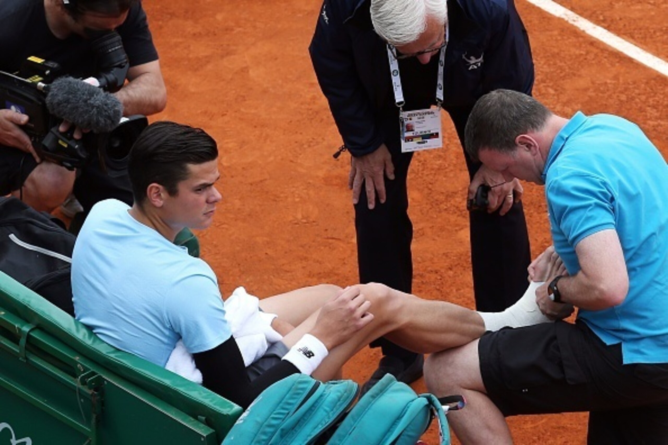 A doctor treats Milos Raonic of Canada during the Monte-Carlo ATP Masters Series Tournament tennis match against Spanish Tommy Robredo, on April 16, 2015 in Monaco. AFP PHOTO / JEAN CHRISTOPHE MAGNENET        (Photo credit should read JEAN CHRISTOPHE MAGN