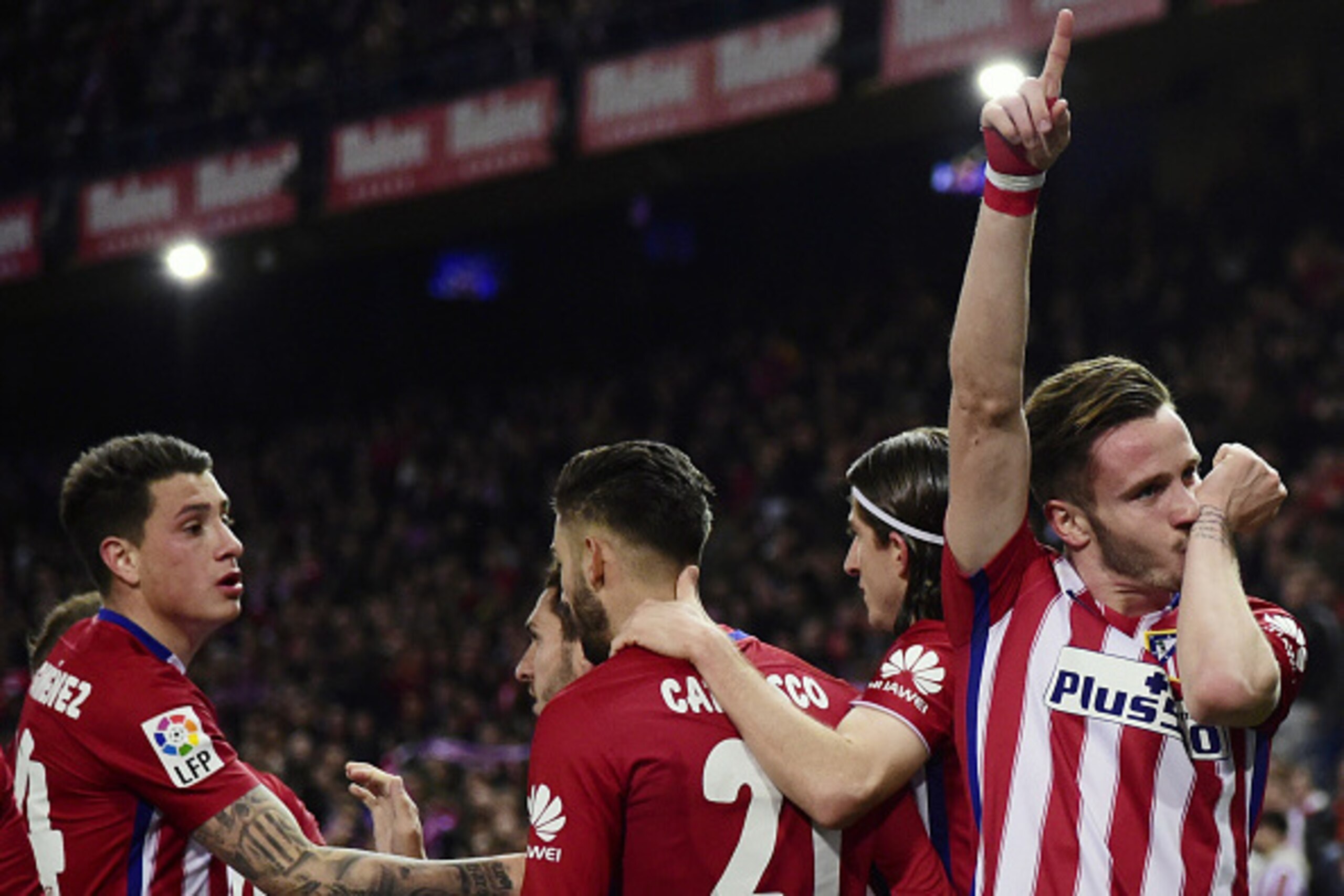 Atletico Madrid's midfielder Saul Niguez (R) celebrates after scoring during the Spanish league football match Club Atletico de Madrid vs RC Deportivo La Coruna at the Vicente Calderon stadium in Madrid on March 12, 2016. / AFP / JAVIER SORIANO        (Ph