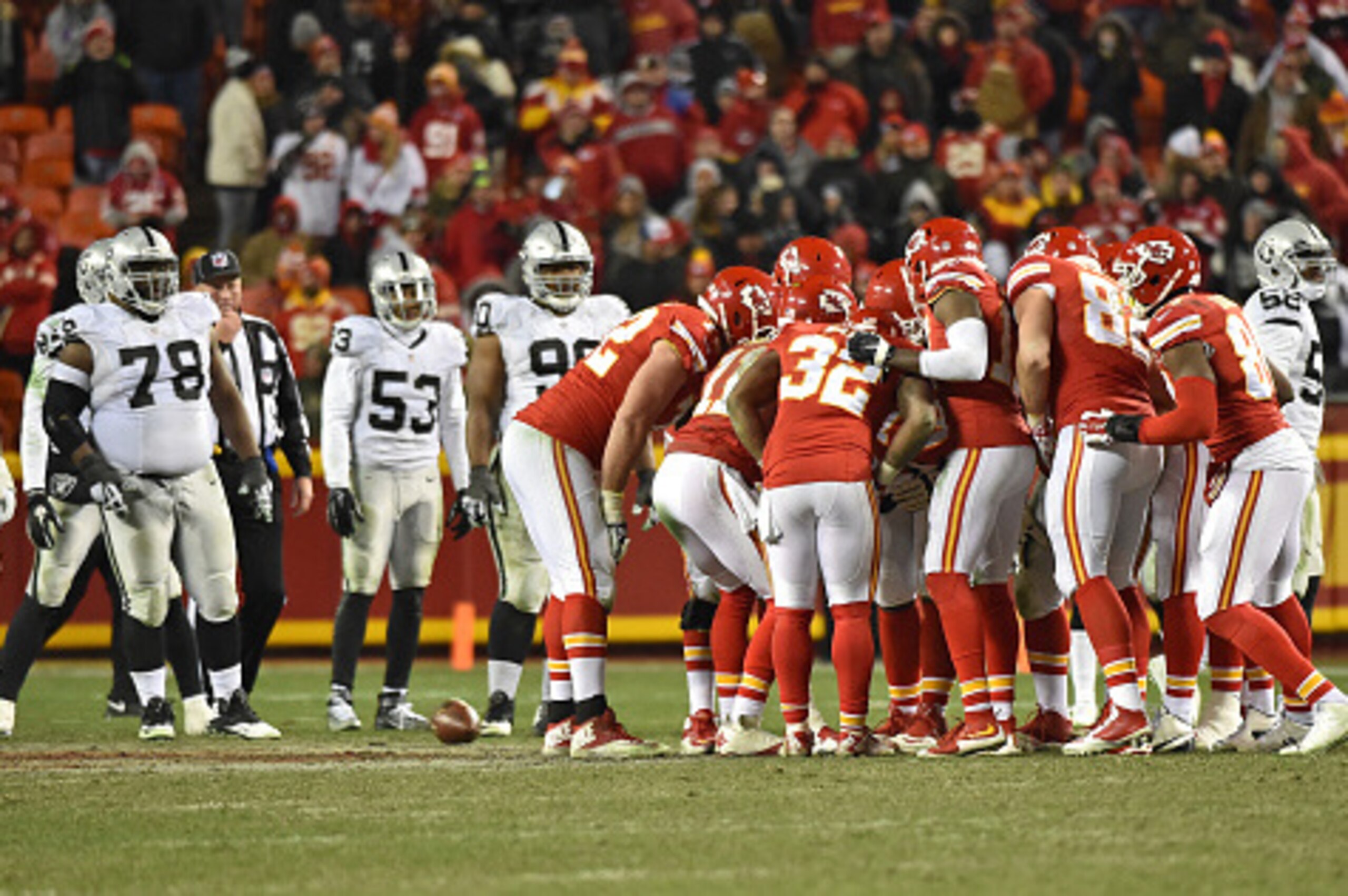 KANSAS CITY, MO - JANUARY 03:  The Kansas City Chiefs huddle as the Oakland Raiders defense looks on during the second half on January 3, 2016 at Arrowhead Stadium in Kansas City, Missouri.  (Photo by Peter G. Aiken/Getty Images)