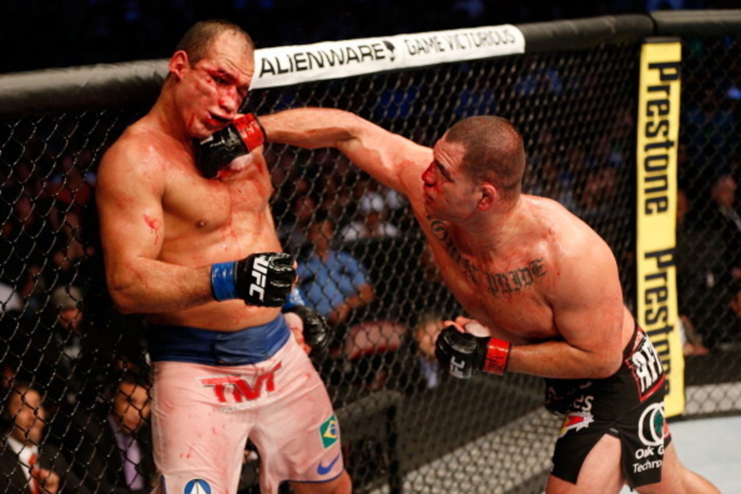 HOUSTON, TEXAS - OCTOBER 19:  (R-L) Cain Velasquez punches Junior Dos Santos in their UFC heavyweight championship bout at the Toyota Center on October 19, 2013 in Houston, Texas. Cain Velasquez defeated Junior Dos Santos by TKO. (Photo by Josh Hedges/Zuf