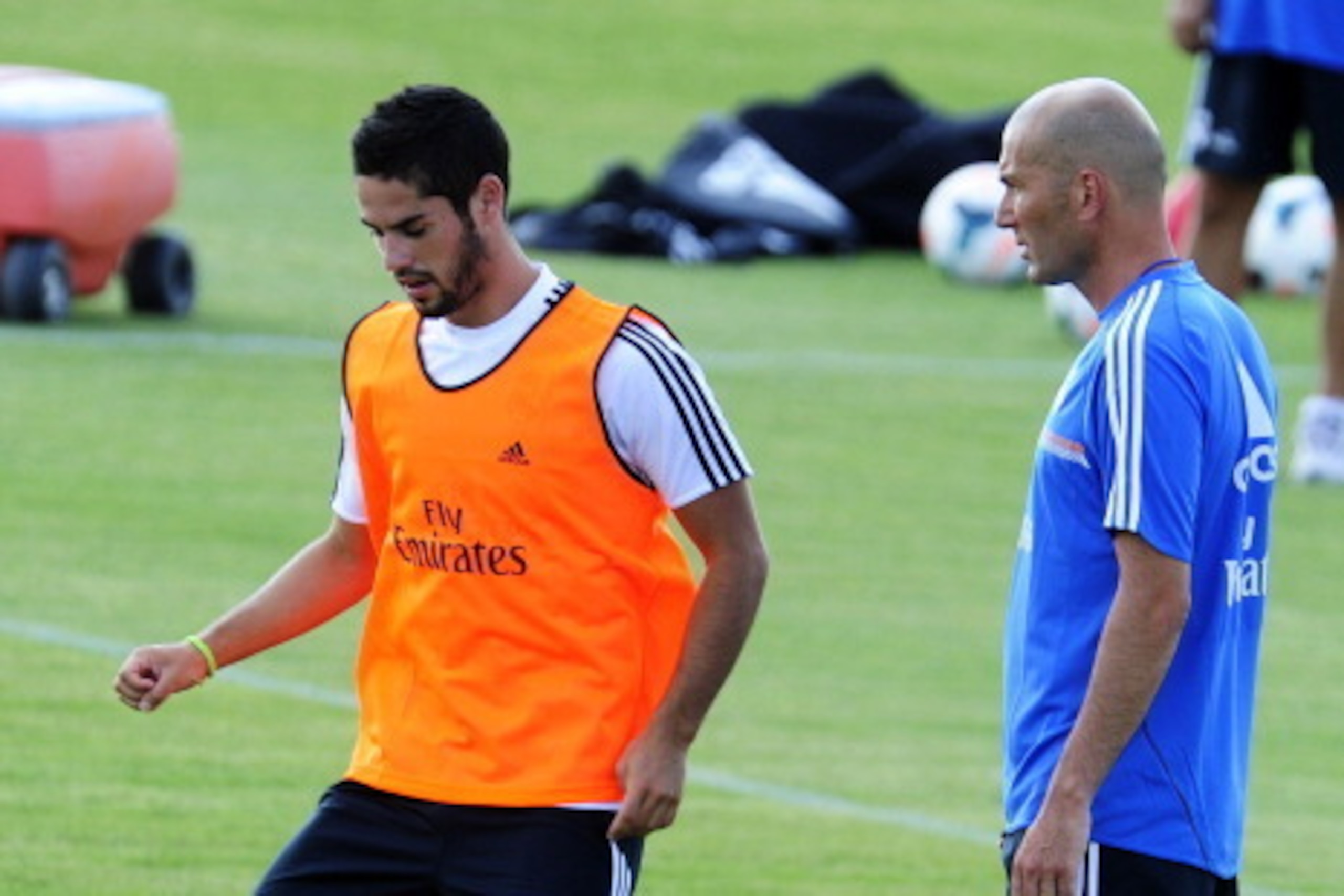 Real Madrid's midfielder Isco (L) and Real Madrid's French assistant coach Zinedine Zidane take part in the first pre-season training session at the Valdebebas training ground in Madrid on July 15, 2013.  AFP PHOTO / DOMINIQUE FAGET        (Photo credit s