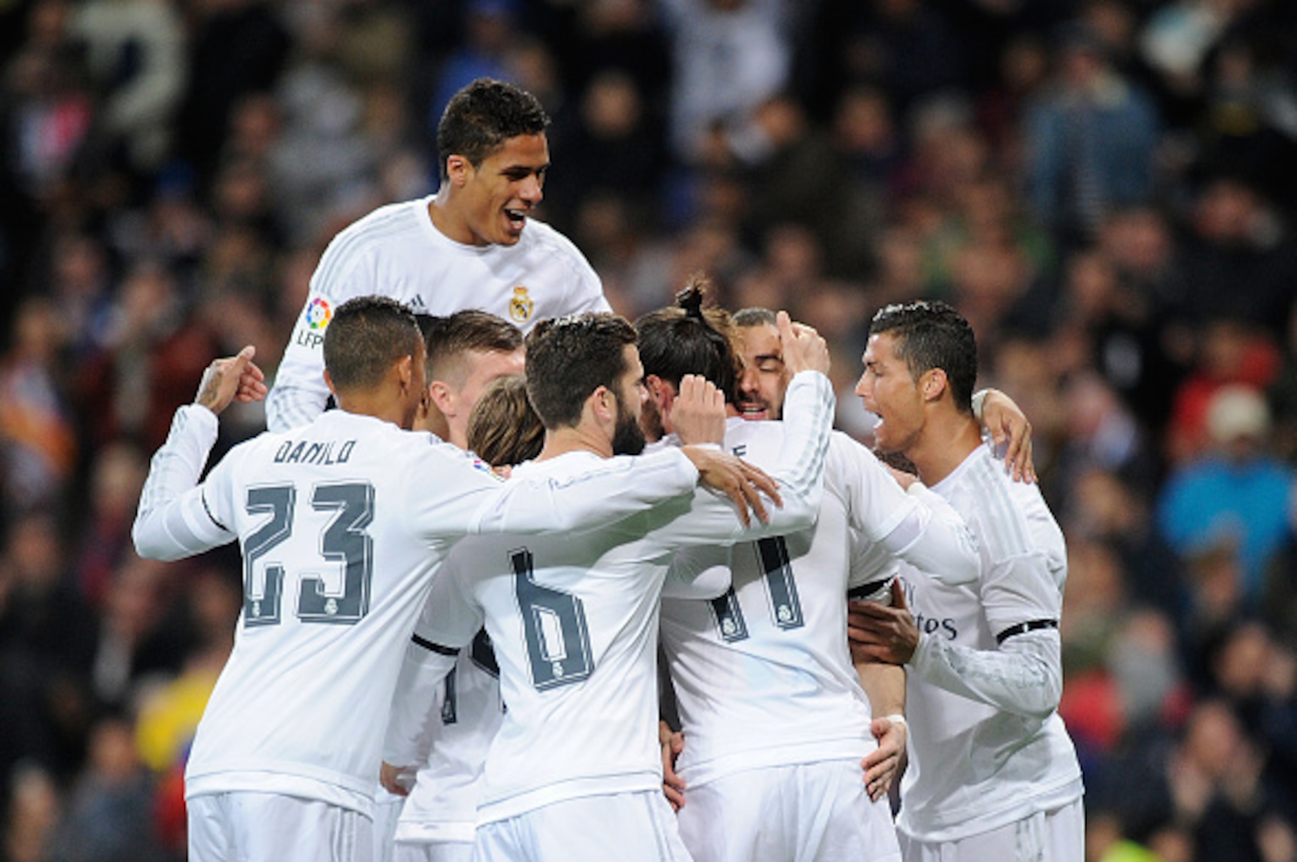 MADRID, SPAIN - MARCH 20:  Karim Benzema (C) of Real Madrid celebrates with Raphael Varane (L) and Cristiano Ronaldo (R) after  scoring Real's opening goal  during the La Liga match between Real Madrid CF and Sevilla FC at Estadio Santiago Bernabeu on Mar