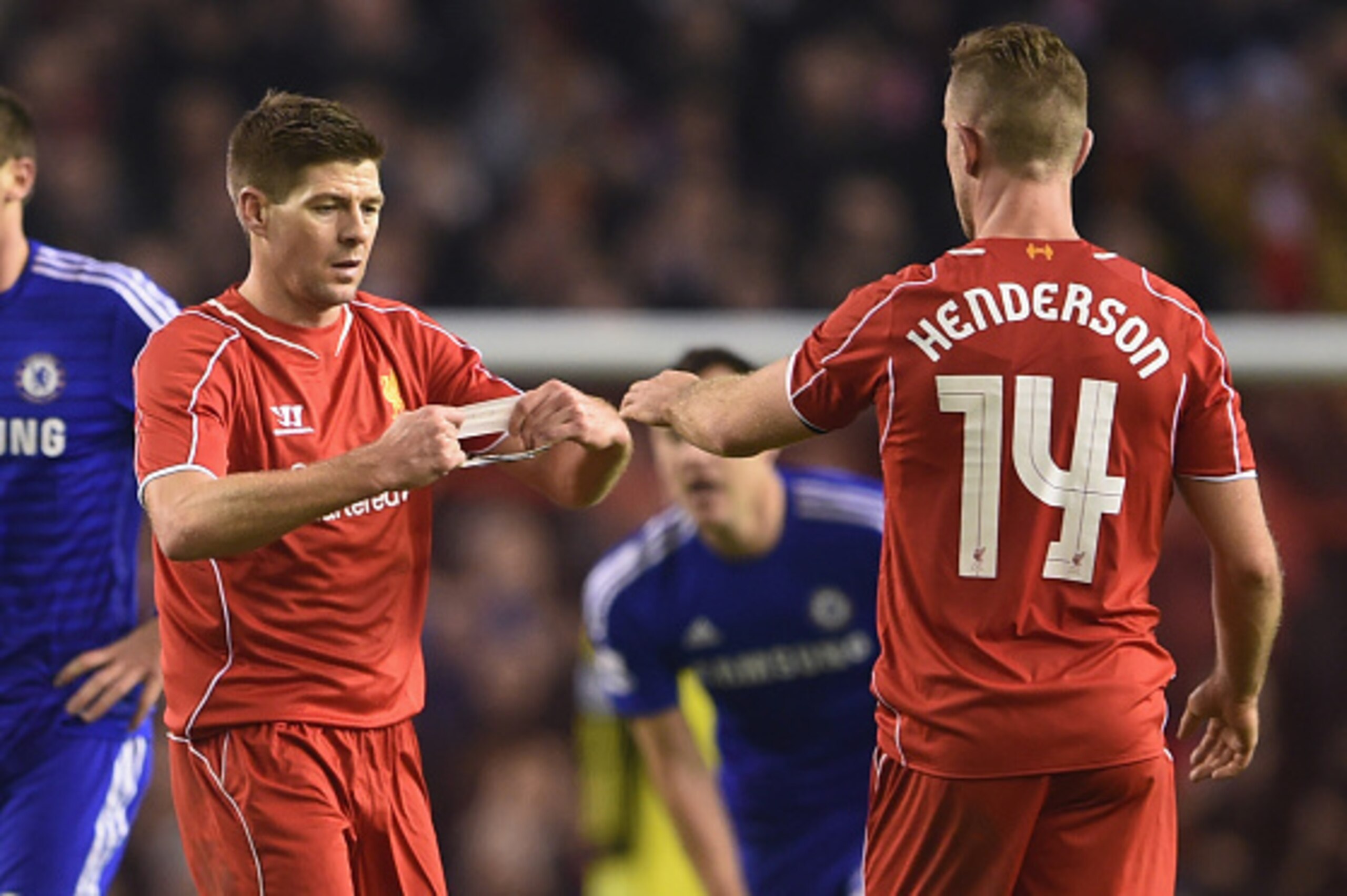 LIVERPOOL, ENGLAND - JANUARY 20:  Steven Gerrard of Liverpool hands the Captain's arm band over to Jordan Henderson of Liverpool during the Capital One Cup Semi-Final first leg match between Liverpool and Chelsea at Anfield on January 20, 2015 in Liverpoo