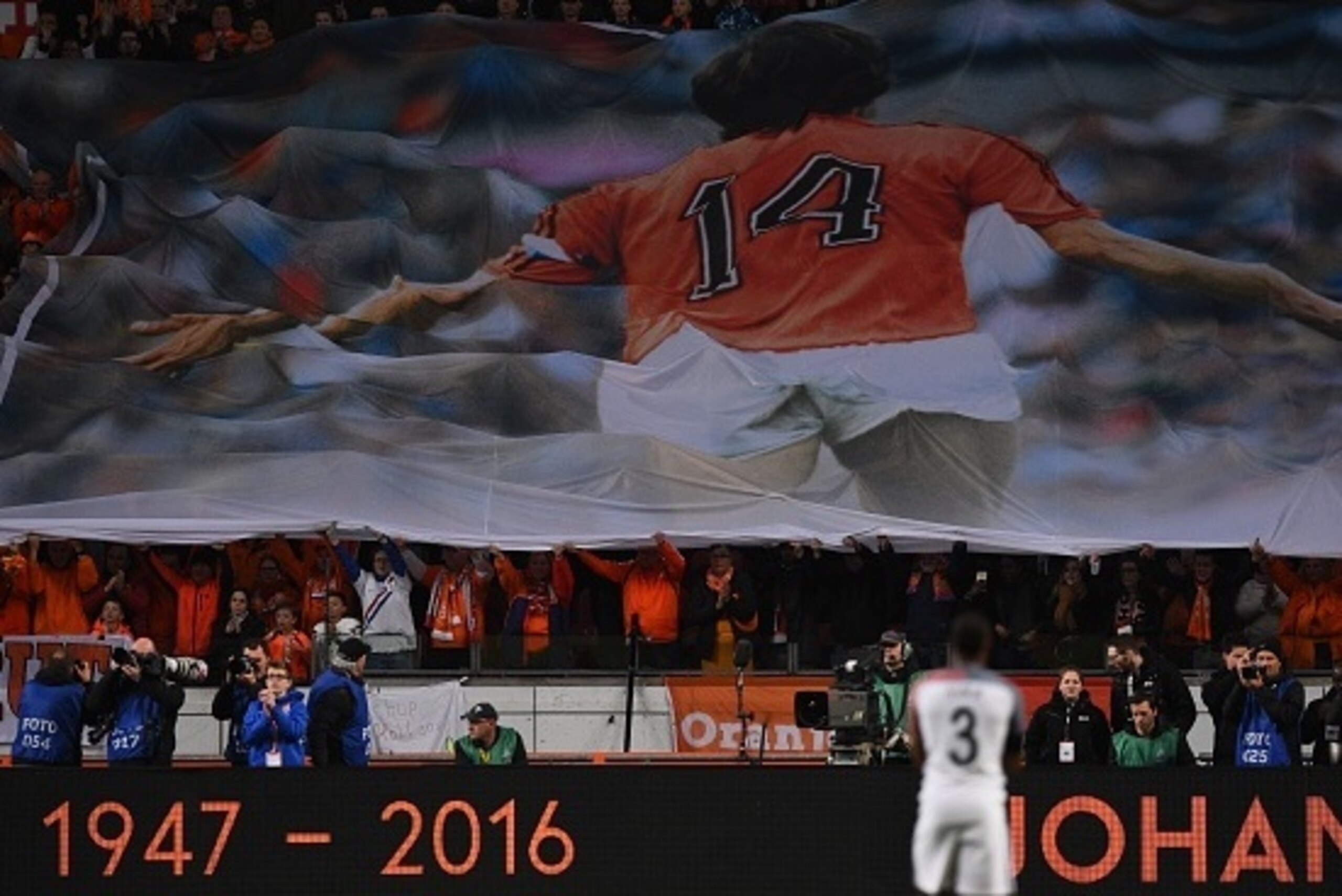 A large banner is displayed during a standing ovation  in honour of late Dutch football legend Johann Cruyff during a pause in the 14th minute of the friendly football match between the Netherlands and France at the Amsterdam ArenA, on March 25, 2016, in 