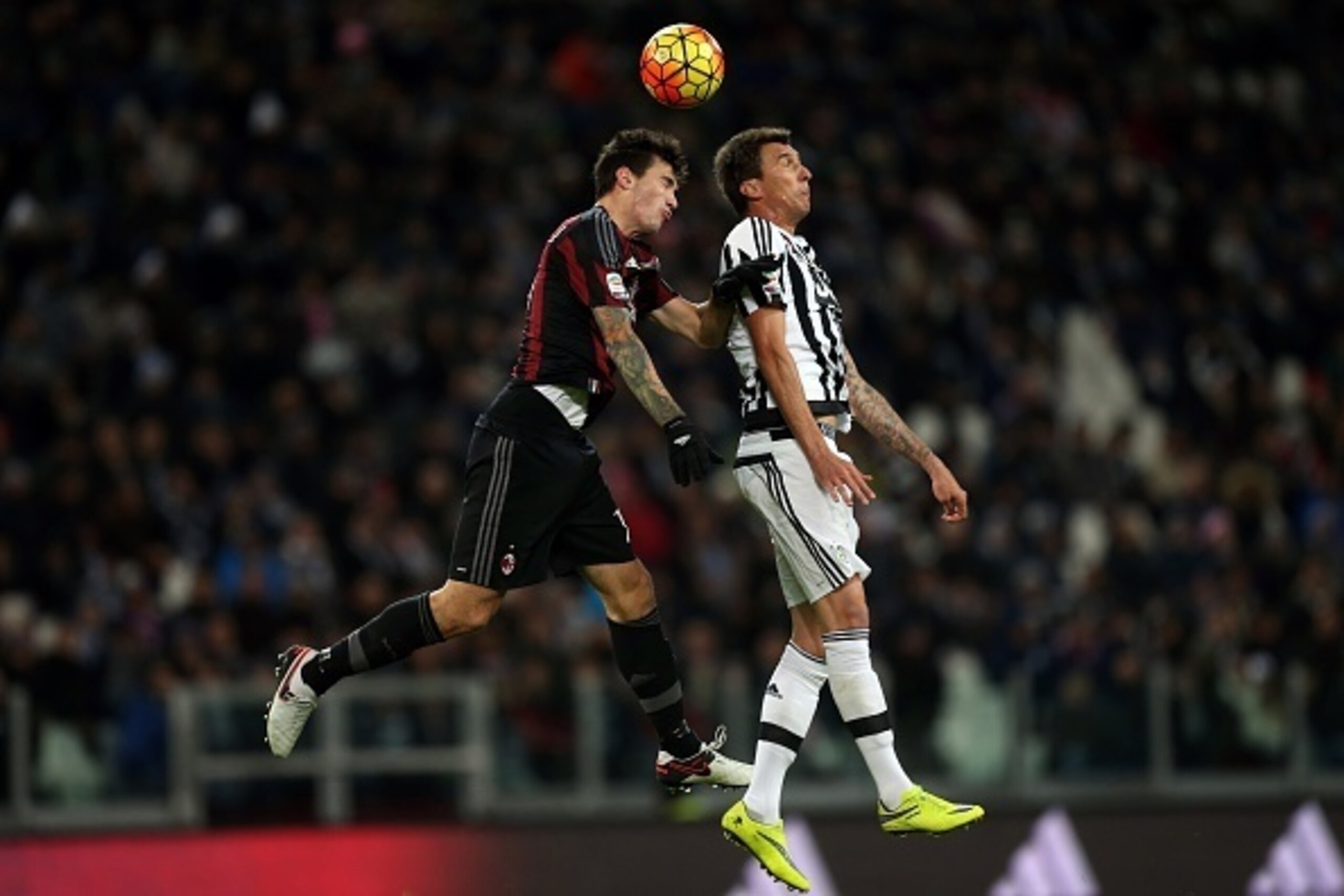 AC Milan's defender Alessio Romagnoli (L) vies with Juventus' Croatian forward Mario Mandzukic during the Italian Serie A  football match Juventus Vs AC Milan on November 21, 2015 at the 'Juventus Stadium' in Turin.  AFP PHOTO / MARCO BERTORELLO        (P