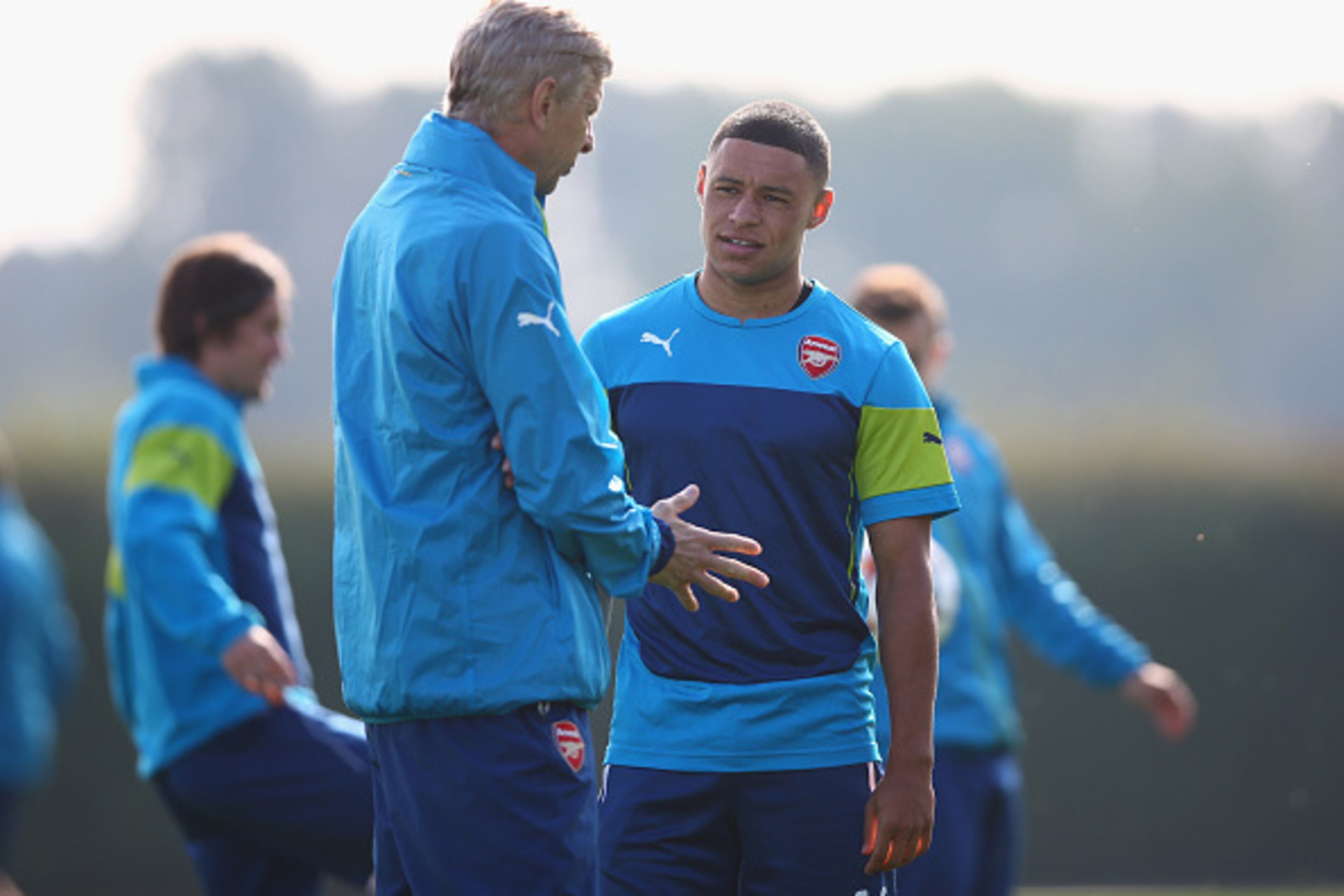 ST ALBANS, ENGLAND - SEPTEMBER 30:  Manager Arsene Wenger of Arsenal talks to Alex Oxlade-Chamberlain during an Arsenal training session ahead of their UEFA Champions League Group D match against Galatasaray at London Colney on September 30, 2014 in St Al