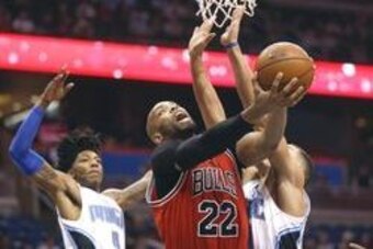 Mar 26, 2016; Orlando, FL, USA; Chicago Bulls forward Taj Gibson (22) goes up for the shot against Orlando Magic forward Aaron Gordon (00) and guard Elfrid Payton (left) during the first quarter of a basketball game at Amway Center. Mandatory Credit: Rein