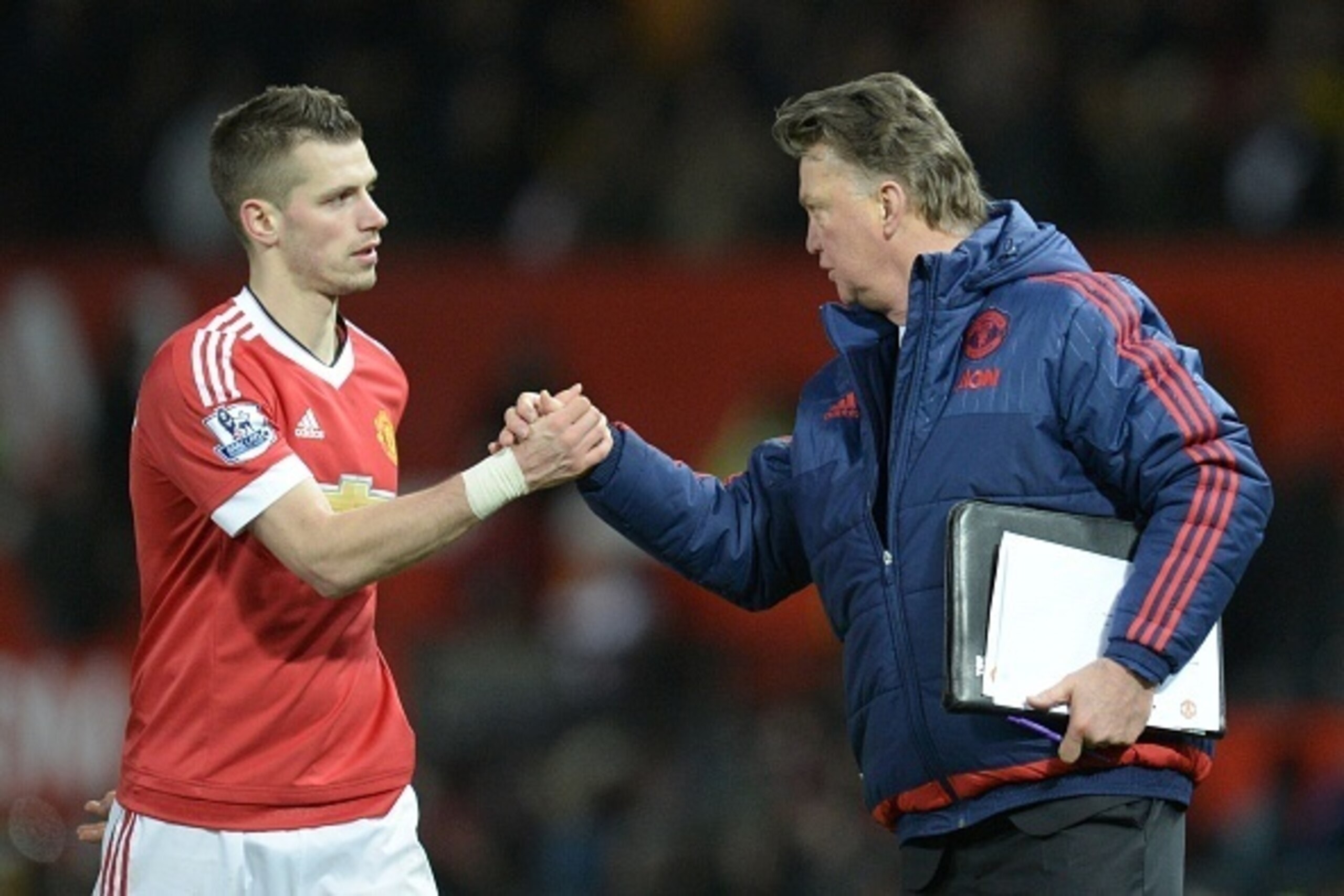 Manchester United's Dutch manager Louis van Gaal (R) shakes hands with Manchester United's French midfielder Morgan Schneiderlin (L) at the end of the English Premier League football match between Manchester United and Watford at Old Trafford in Mancheste