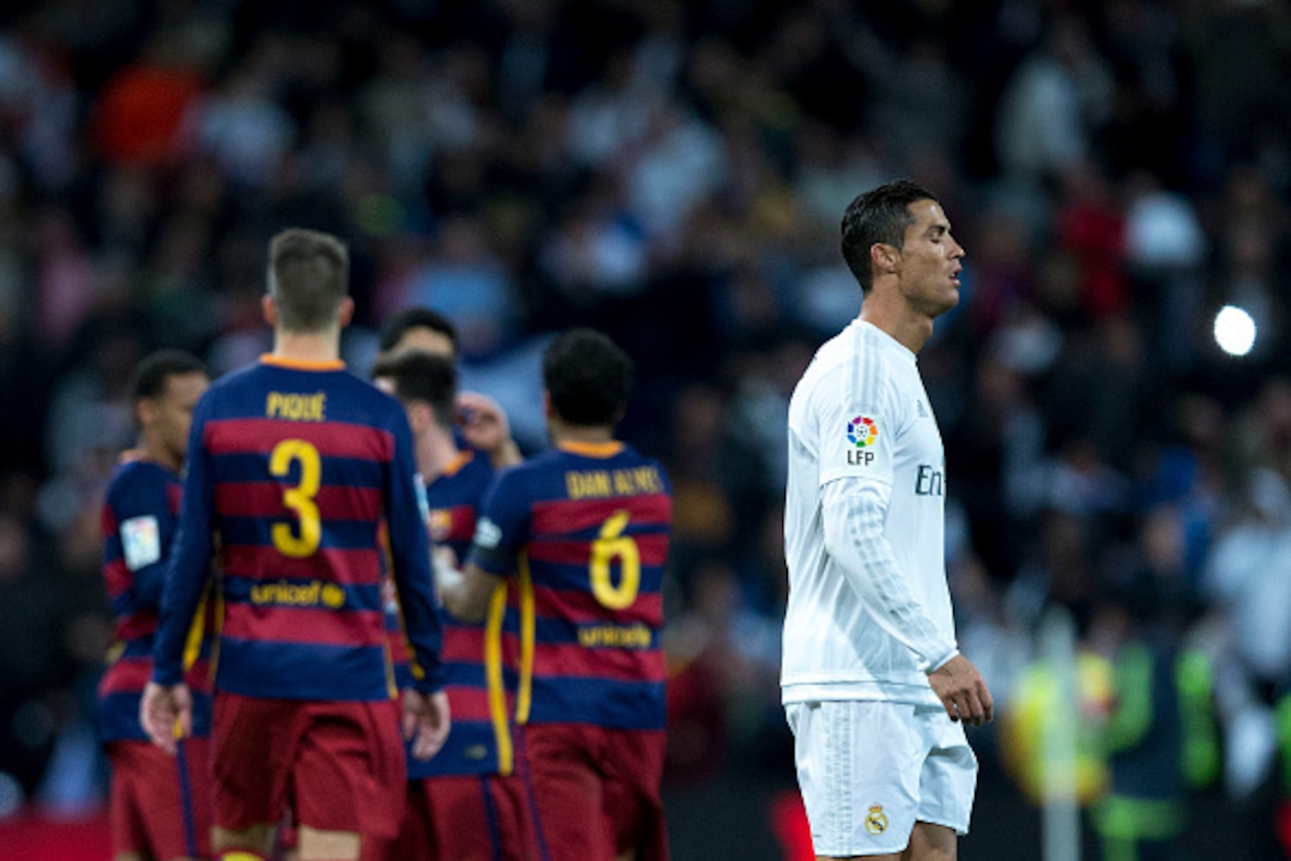 MADRID, SPAIN - NOVEMBER 21:  Cristiano Ronaldo of Real Madrid CF leaves the pithc as FC Barcelona players celebrate their victory after the La Liga match between Real Madrid CF and FC Barcelona at Estadio Santiago Bernabeu on November 21, 2015 in Madrid,