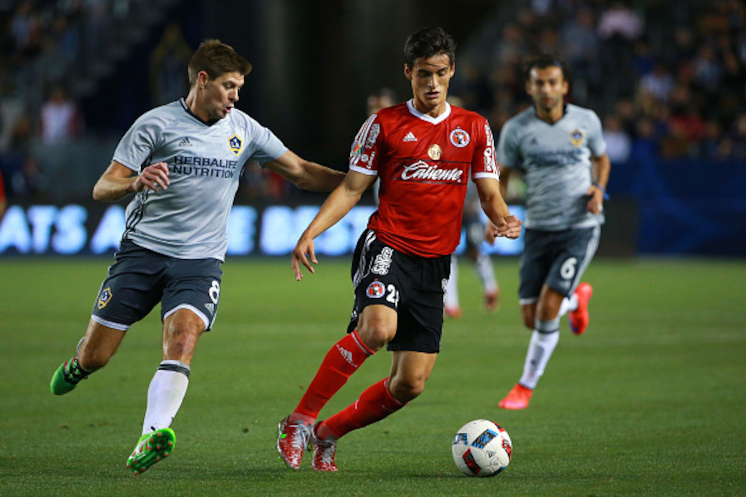 CARSON, CA - FEBRUARY 09: Steven Gerrard #8 of Los Angeles Galaxy challenges Fernando Arce #287 of Club Tijuana for the ball during the second half of their club friendly match at StubHub Center on February 9, 2016 in Carson, California. Club Tijuana and 