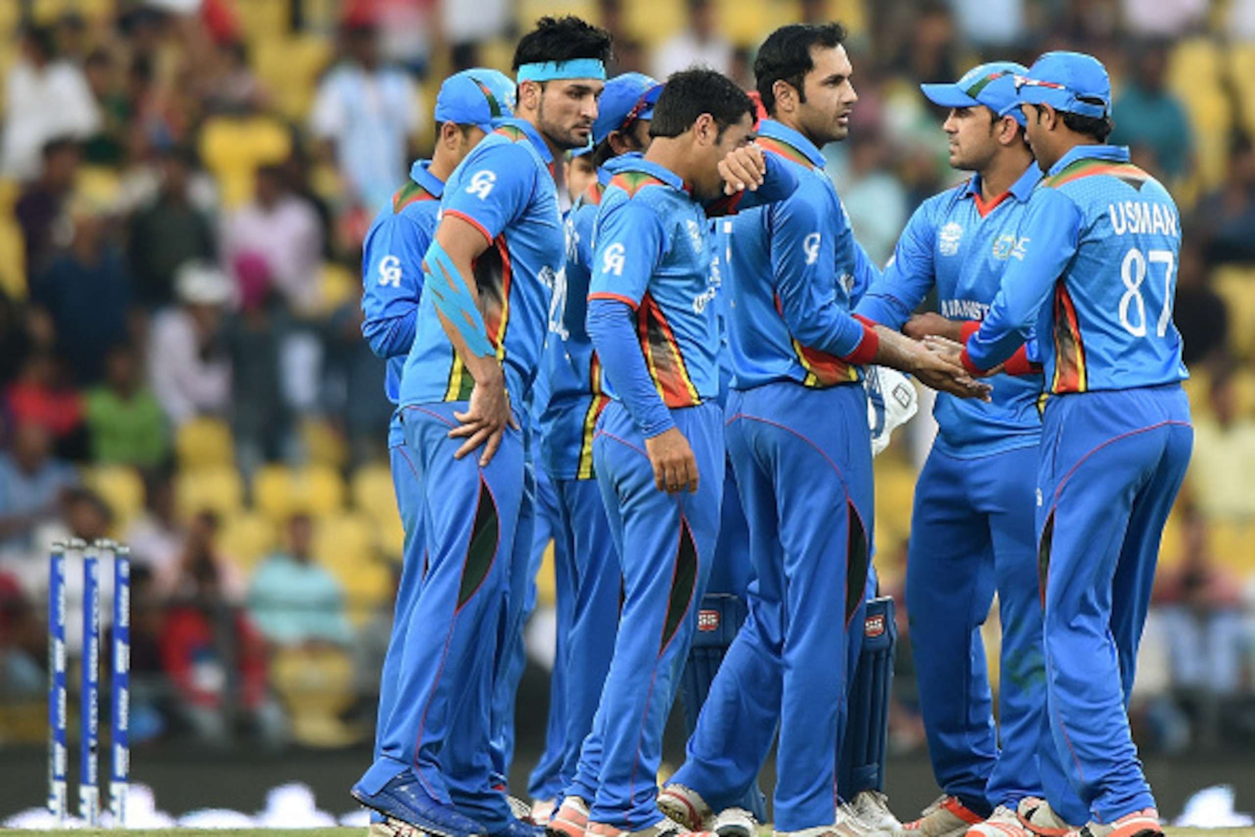 Afghanistan's players gather as they celebrate after the wicket of West Indies's batsman Dwayne Bravo during the World T20 cricket tournament match between West Indies and Afghanistan at The Vidarbha Cricket Association Stadium in Nagpur on March 27, 2016