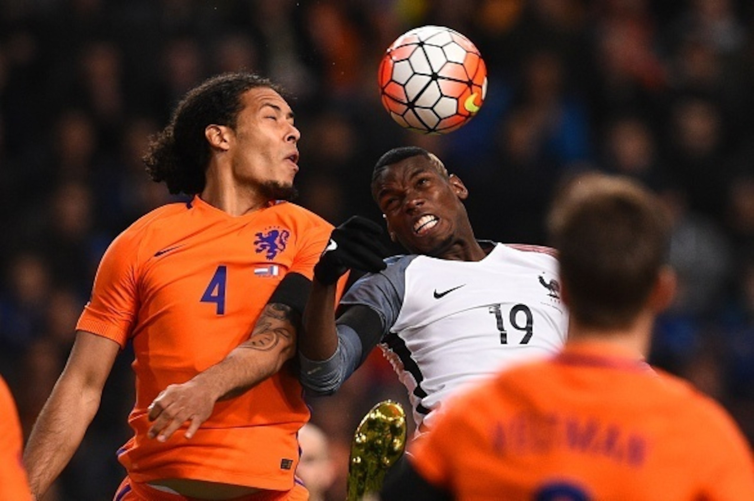 France's midfielder Paul Pogba (R) jumps for the ball with Netherland's defender Virgil Van Dijk (L) during the friendly football match between the Netherlands and France at the Amsterdam ArenA, on March 25, 2016, in Amsterdam. AFP PHOTO / FRANCK FIFE / A