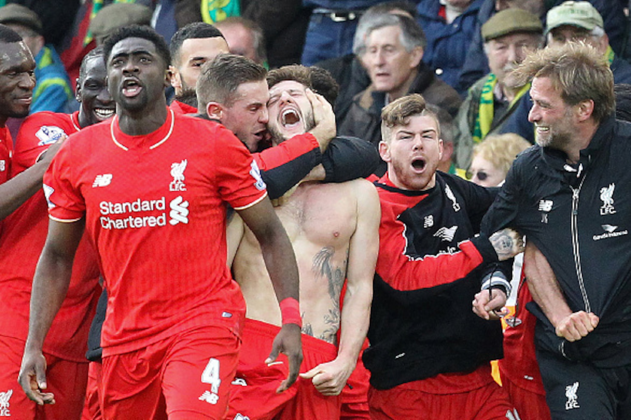 With his shirt off, Liverpool's English midfielder Adam Lallana (C) celebrates scoring their late winning goal with teammates and Liverpool's German manager Jurgen Klopp (3rd R), as Norwich City's Scottish coach Alex Neil (R) looks on during the English P