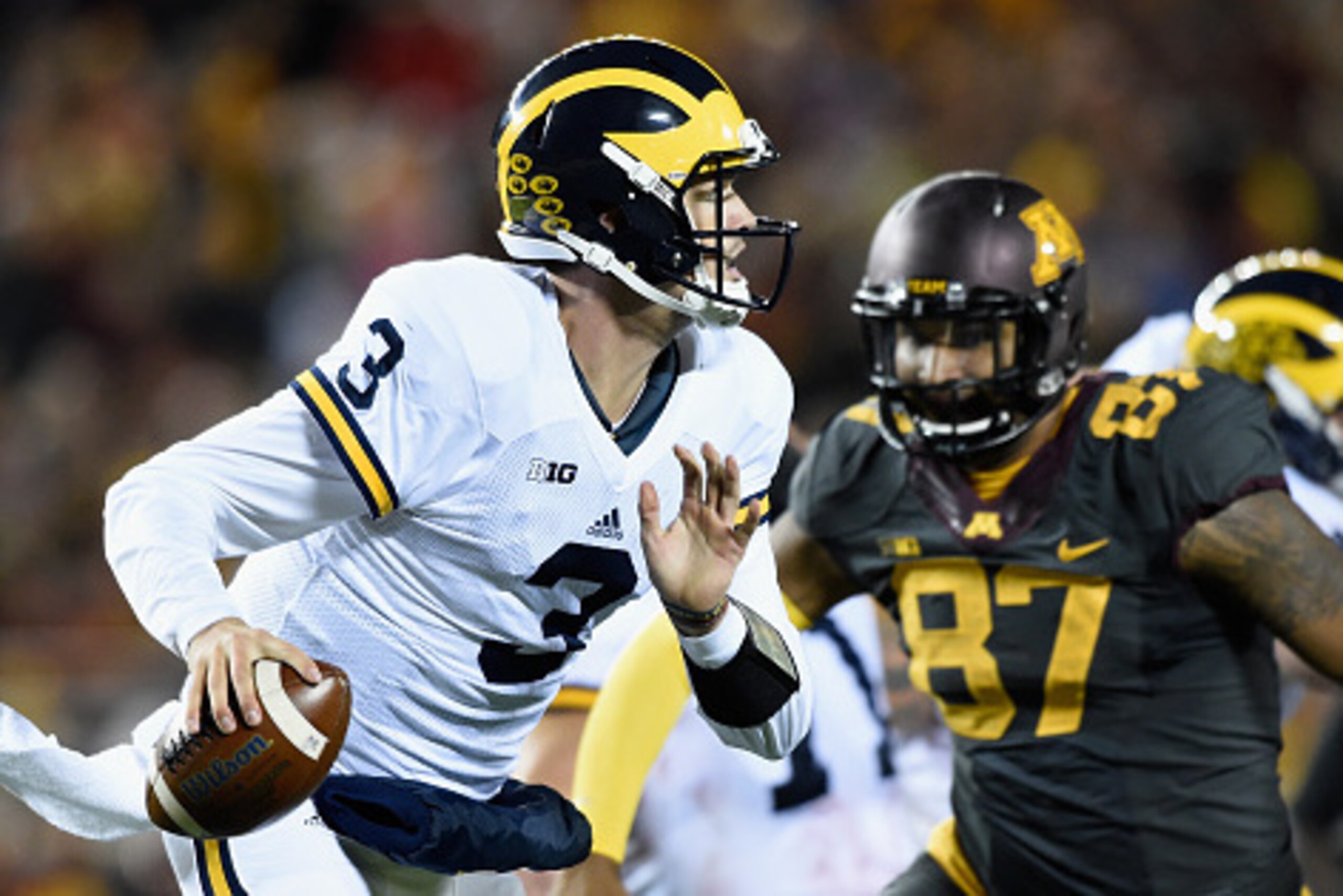 MINNEAPOLIS, MN - OCTOBER 31: Wilton Speight #3 of the Michigan Wolverines scrambles with the ball with pressure from Gaelin Elmore #87 of the Minnesota Golden Gophers during the fourth quarter of the game on October 31, 2015 at TCF Bank Stadium in Minnea