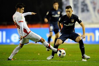 Rayo Vallecano's midfielder Jozabed Sanchez Ruiz (L) vies with Atletico Madrid's Argentinian Matias Kranevitter (L) during the Spanish Copa del Rey (King's Cup) round of 16 first leg football match Club Atletico de Madrid vs CF Rayo Vallecano  at the Vall