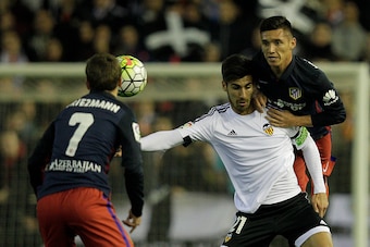 Valencia's Portuguese midfielder Andre Gomes (C) vies with Atletico Madrid's Argentinian midfielder Matias Kranevitter (R) during the Spanish league football match Club Valencia CF vs Atletico de Madrid at Mestalla stadium in Valencia on March 6, 2016. / 