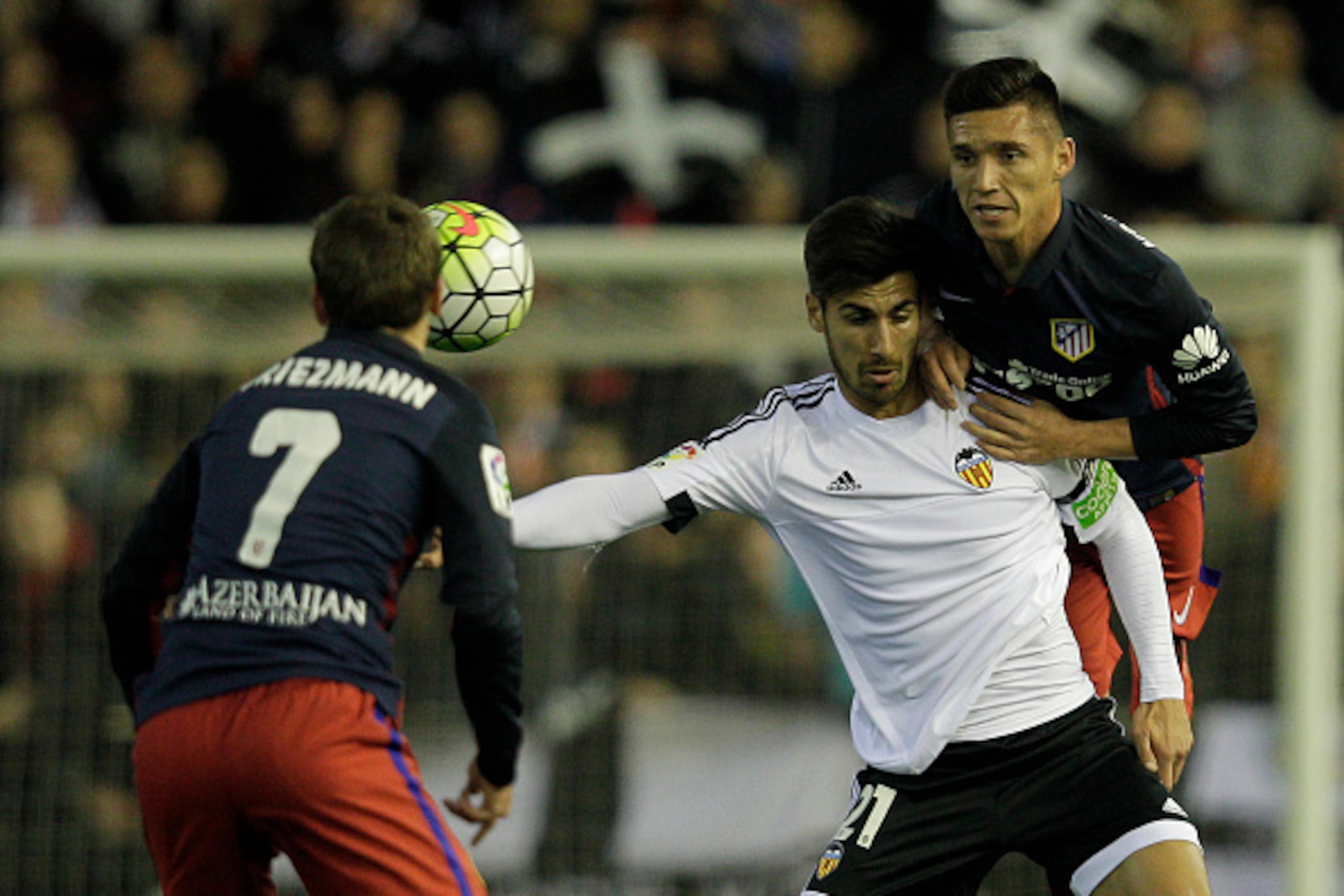 Valencia's Portuguese midfielder Andre Gomes (C) vies with Atletico Madrid's Argentinian midfielder Matias Kranevitter (R) during the Spanish league football match Club Valencia CF vs Atletico de Madrid at Mestalla stadium in Valencia on March 6, 2016. / 