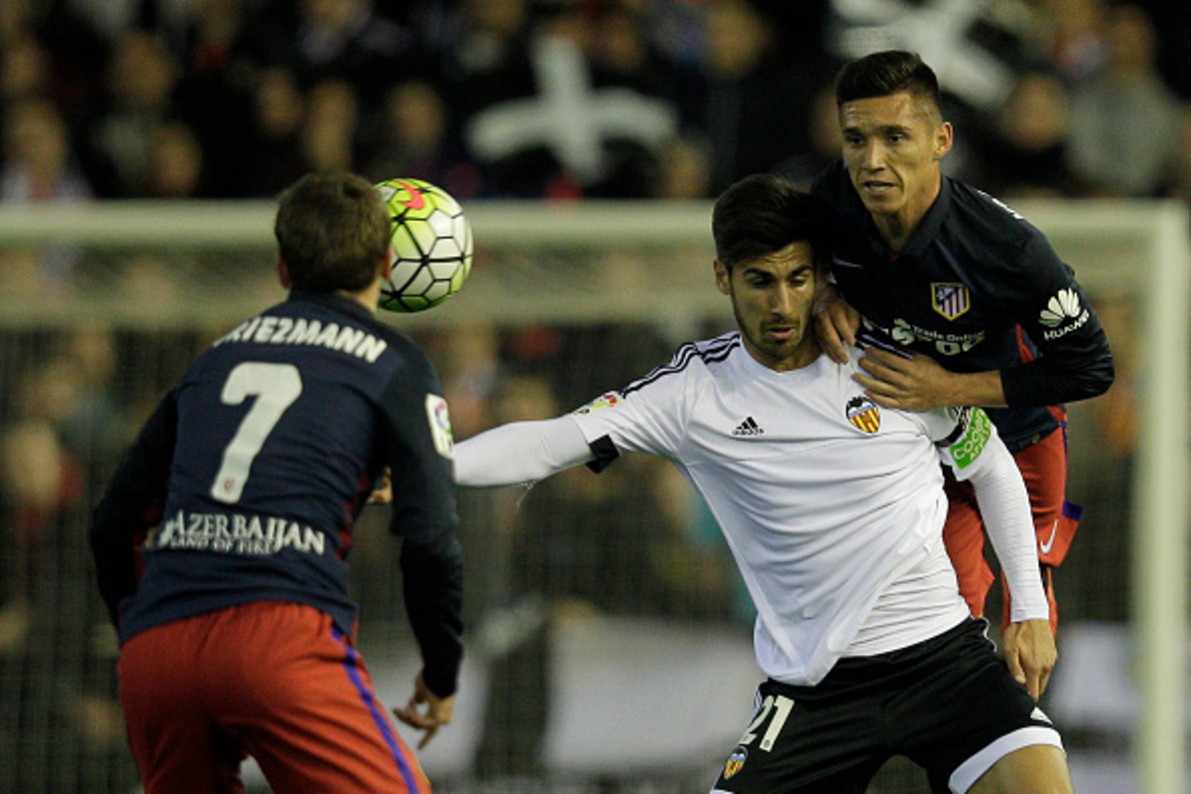 Valencia's Portuguese midfielder Andre Gomes (C) vies with Atletico Madrid's Argentinian midfielder Matias Kranevitter (R) during the Spanish league football match Club Valencia CF vs Atletico de Madrid at Mestalla stadium in Valencia on March 6, 2016. / 