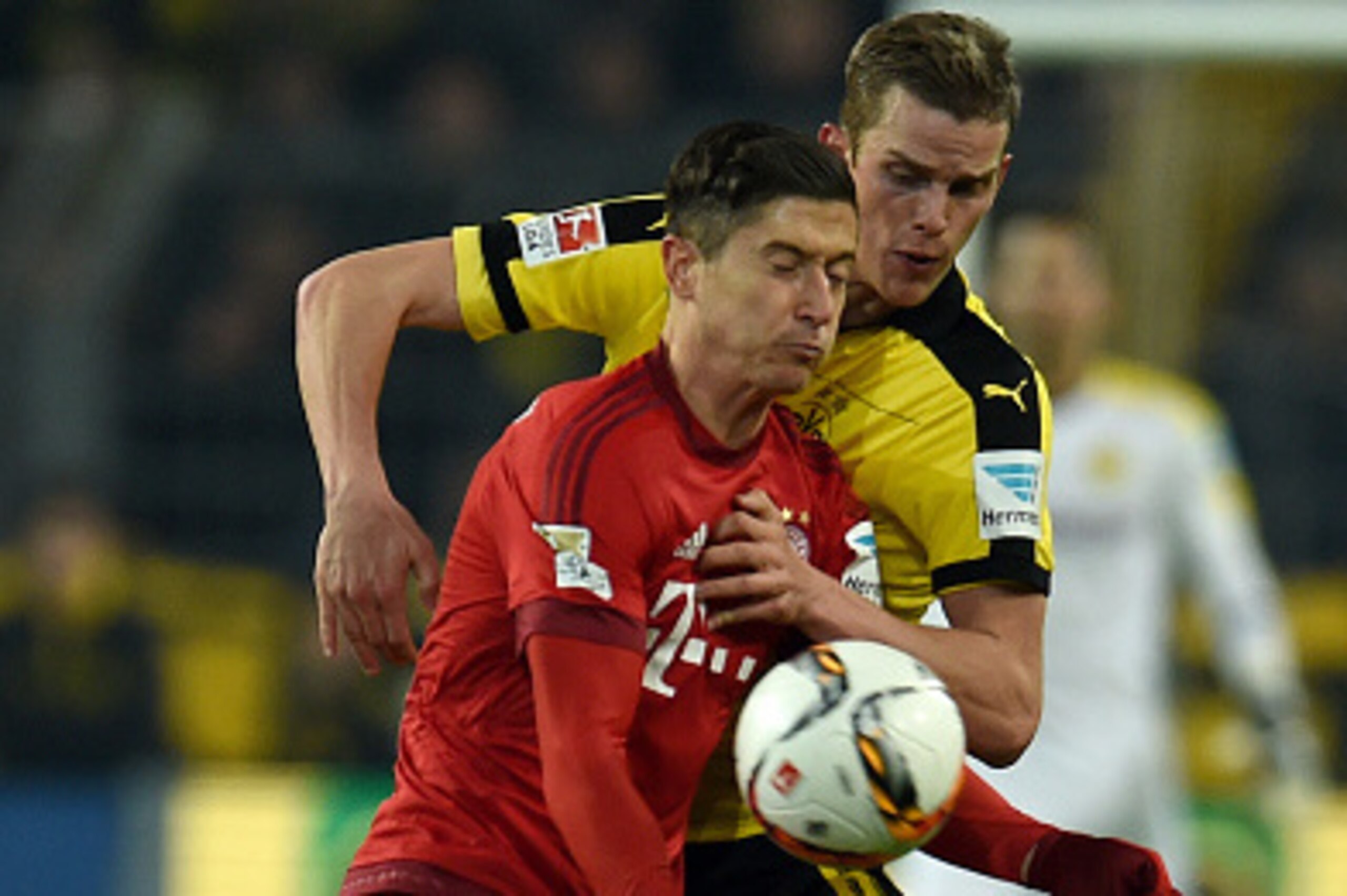 Dortmund's midfielder Sven Bender (R) and Bayern Munich's Polish striker Robert Lewandowski vie for the ball  during the German first division Bundesliga football match of Borussia Dortmund v FC Bayern Muenchen in Dortmund, on March 5, 2016. / AFP / PATRI