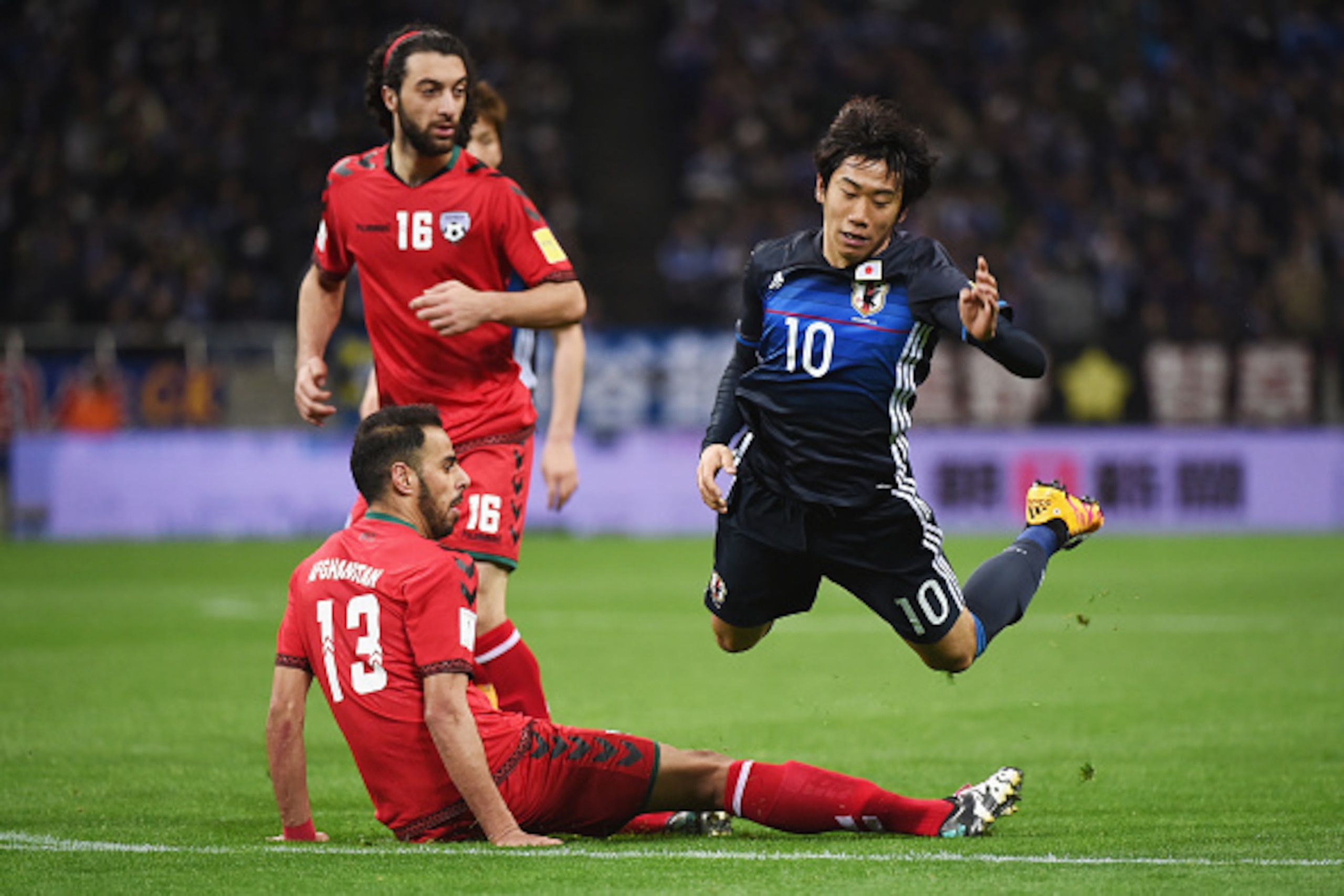 SAITAMA, JAPAN - MARCH 24:  Shinji Kagawa of Japan is tackled by Sayed Mohammad of Afghanistan during the FIFA World Cup Russia Asian Qualifier second round match between Japan and Afghanistan at the Saitama Stadium on March 24, 2016 in Saitama, Japan.  (