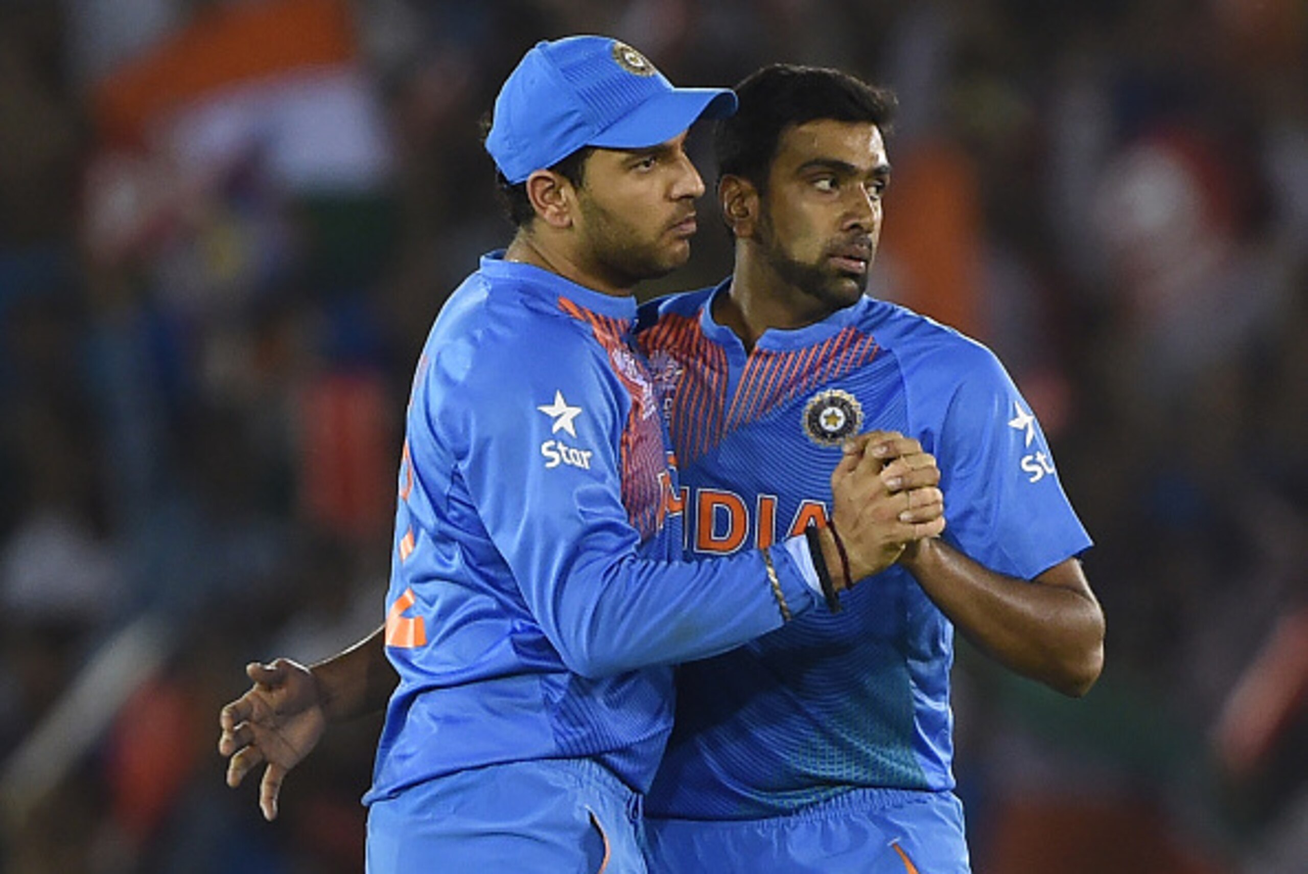 India's Ravichandran Ashwin(R)celebrates with teammate Vuvraj Singh after his dismissal of Australia's David Warner during the World T20 cricket tournament match between India and Australia at The Punjab Cricket Stadium Association Stadium in Mohali on Ma