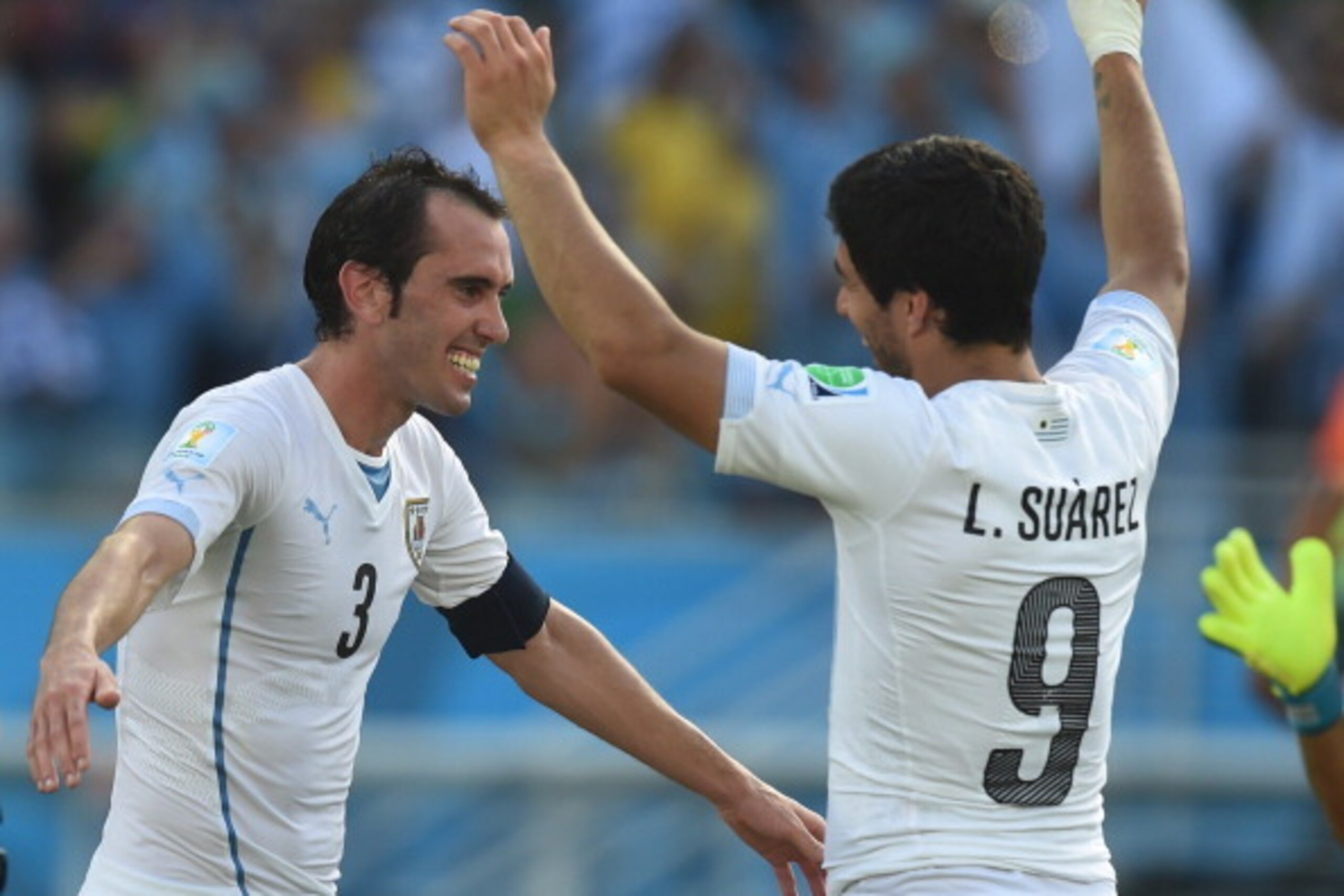 Uruguay's defender Diego Godin (L) celebrates their victory with Uruguay's forward Luis Suarez at the end of a Group D football match between Italy and Uruguay at the Dunas Arena in Natal during the 2014 FIFA World Cup on June 24, 2014. Uruguay won 1-0.