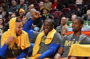 CLEVELAND, OH - JANUARY 18: Harrison Barnes #40, Draymond Green #23 , Stephen Curry #30 and Klay Thompson #11 of the Golden State Warriors smiles from the bench against the Cleveland Cavaliers on January 18, 2016 at Quicken Loans Arena in Cleveland, Ohio.