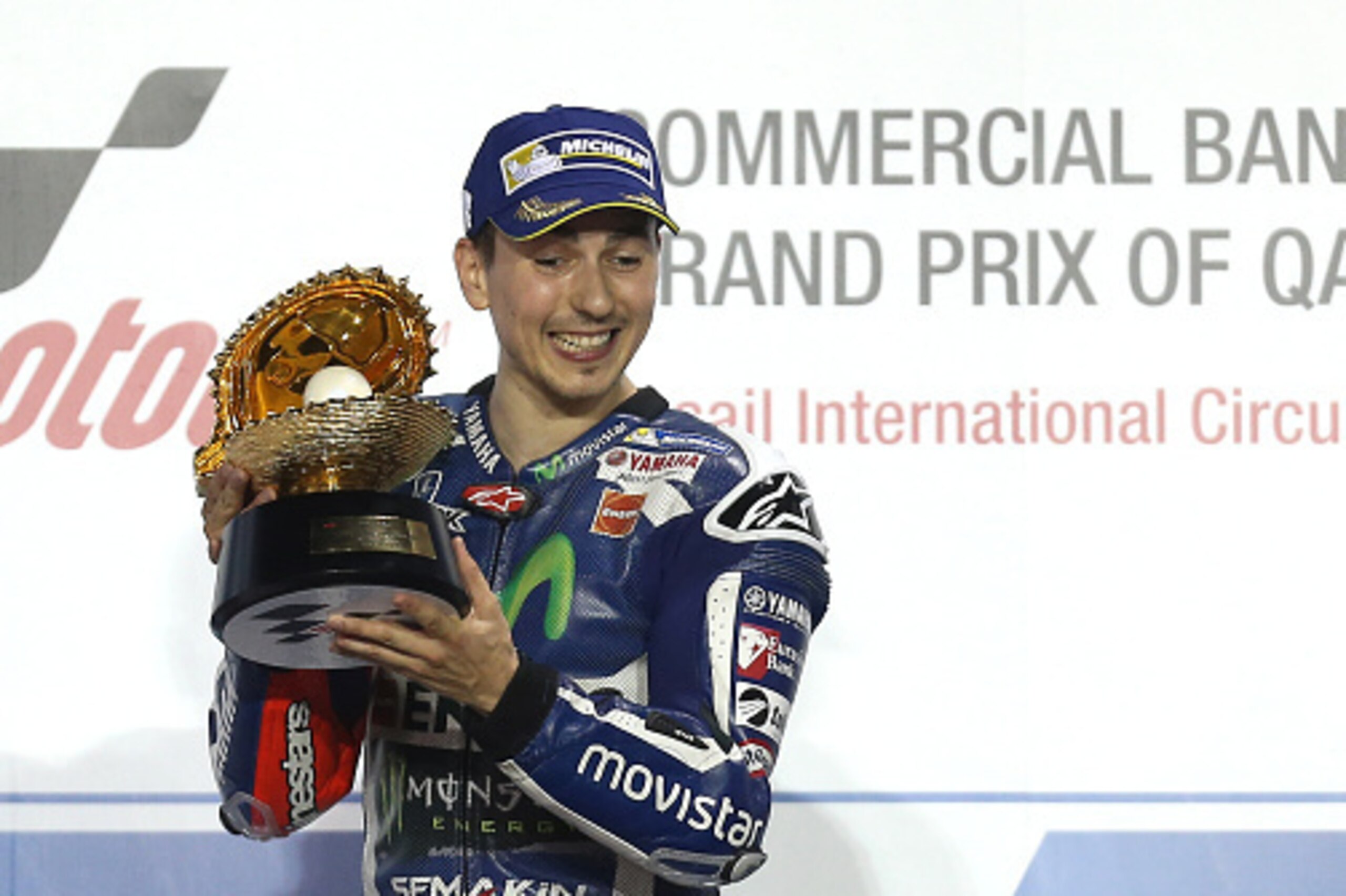 Spanish rider Jorge Lorenzo of Movistar Yamaha MotoGP celebrates with the trophy on the podium on March 20, 2016 after winning the Qatar Grand Prix at the Losail International Circuit in the capital Doha. / AFP / KARIM JAAFAR        (Photo credit should r
