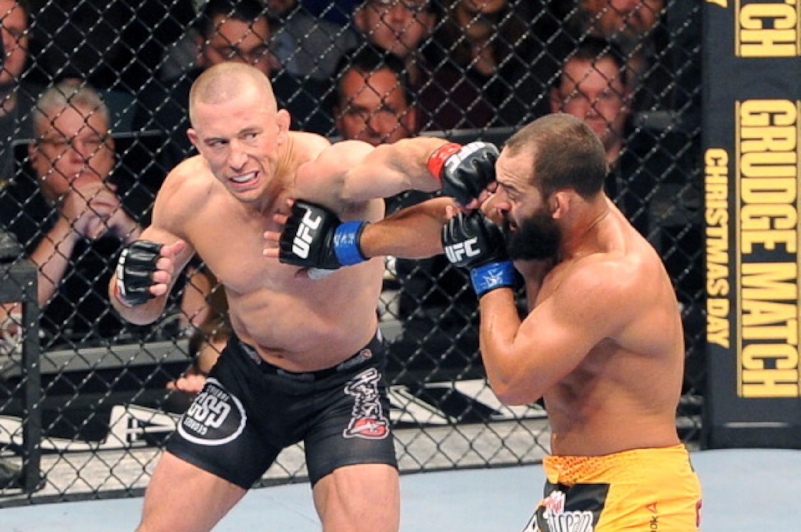 LAS VEGAS, NEVADA - NOVEMBER 16:  Georges St-Pierre (L) punches Johny Hendricks in their UFC welterweight championship bout during the UFC 167 event at the MGM Grand Garden Arena on November 16, 2013 in Las Vegas, Nevada. (Photo by Jeff Bottari/Zuffa LLC/