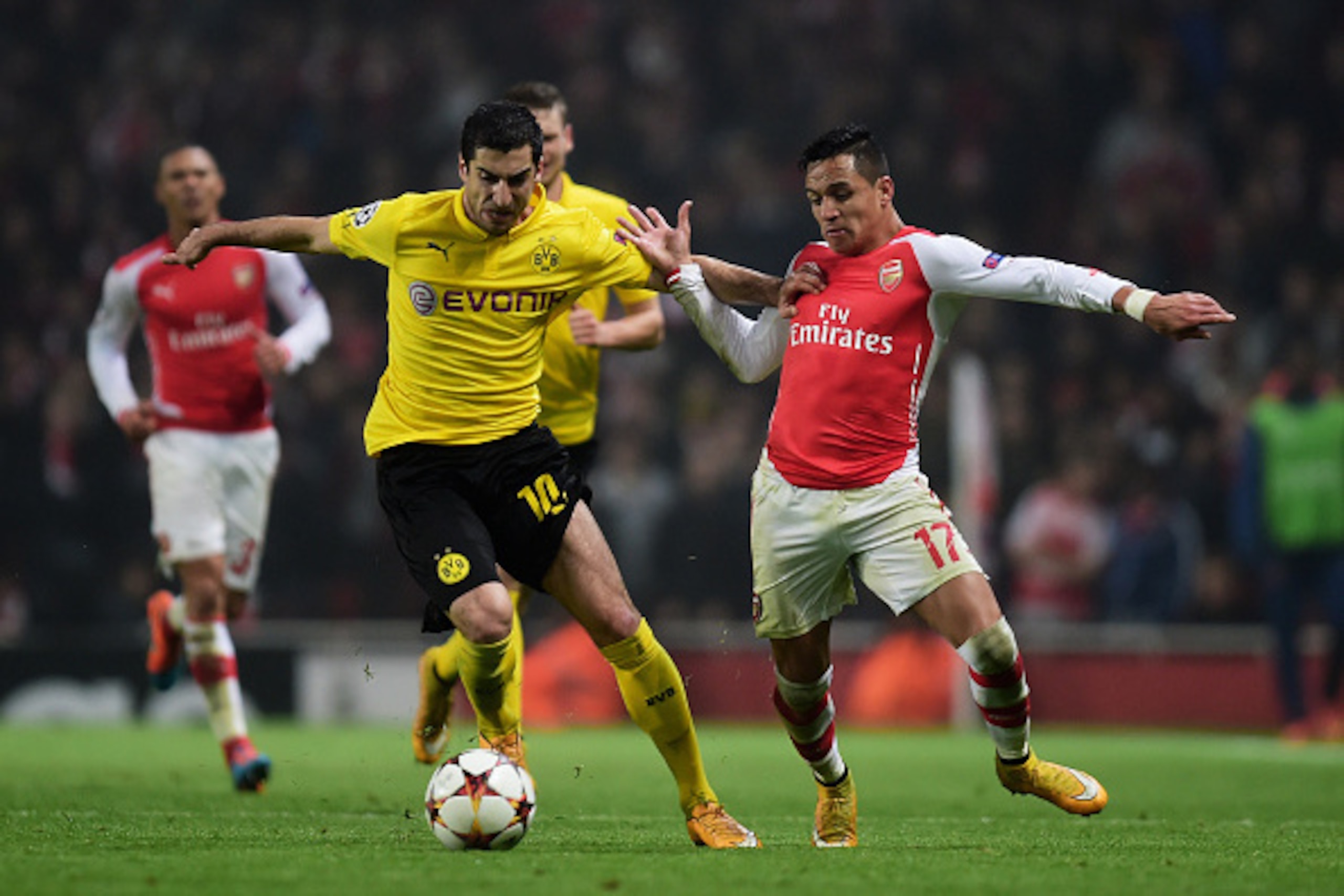 LONDON, ENGLAND - NOVEMBER 26:  Henrikh Mkhitaryan of Borussia Dortmund and Alexis Sanchez of Arsenal battle for the ball during the UEFA Champions League Group D match between Arsenal and Borussia Dortmund at the Emirates Stadium on November 26, 2014 in 