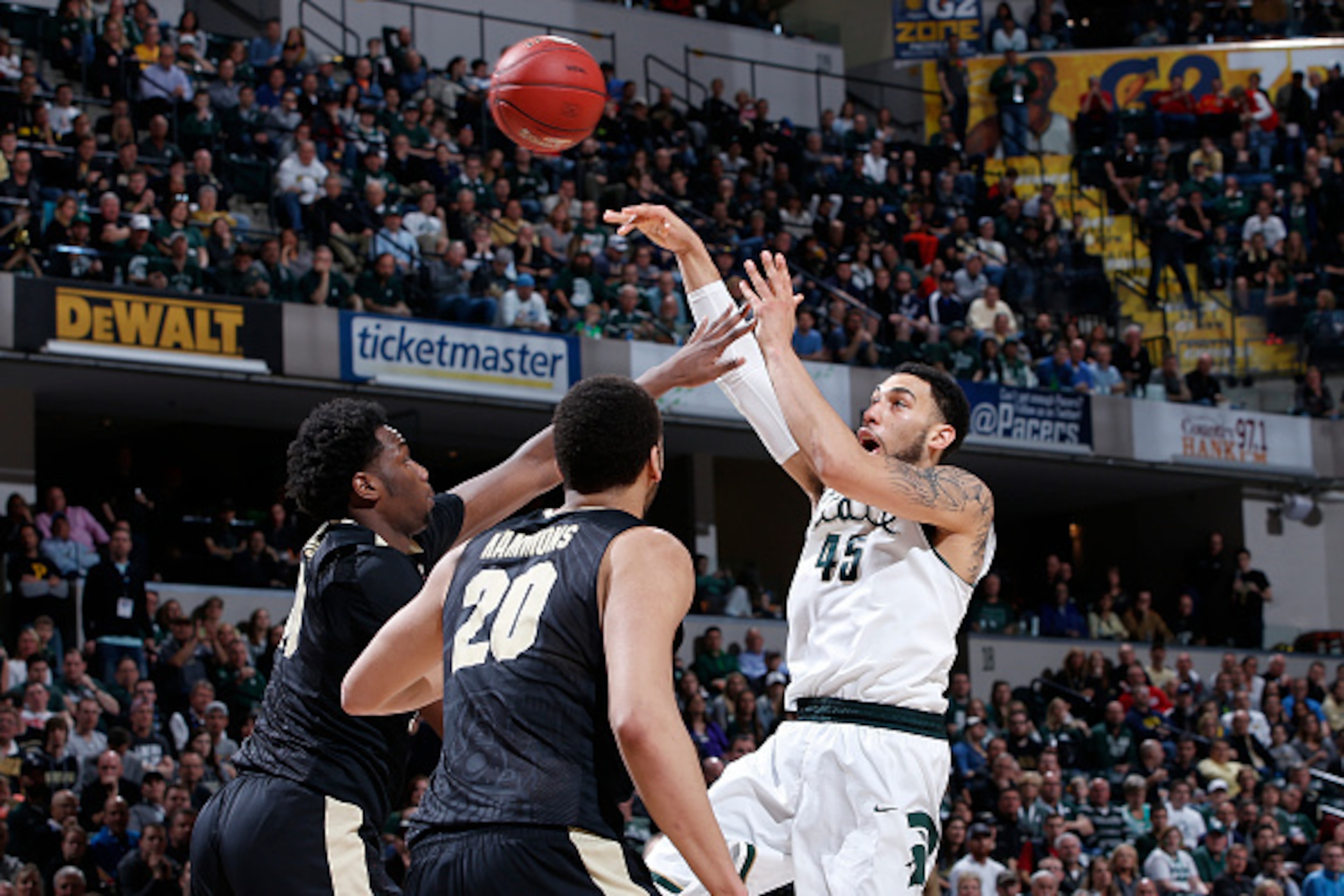 INDIANAPOLIS, IN - MARCH 13: Denzel Valentine #45 of the Michigan State Spartans passes while defended by Caleb Swanigan #50 and A.J. Hammons #20 of the Purdue Boilermakers in the championship game of the Big Ten Basketball Tournament at Bankers Life Fiel