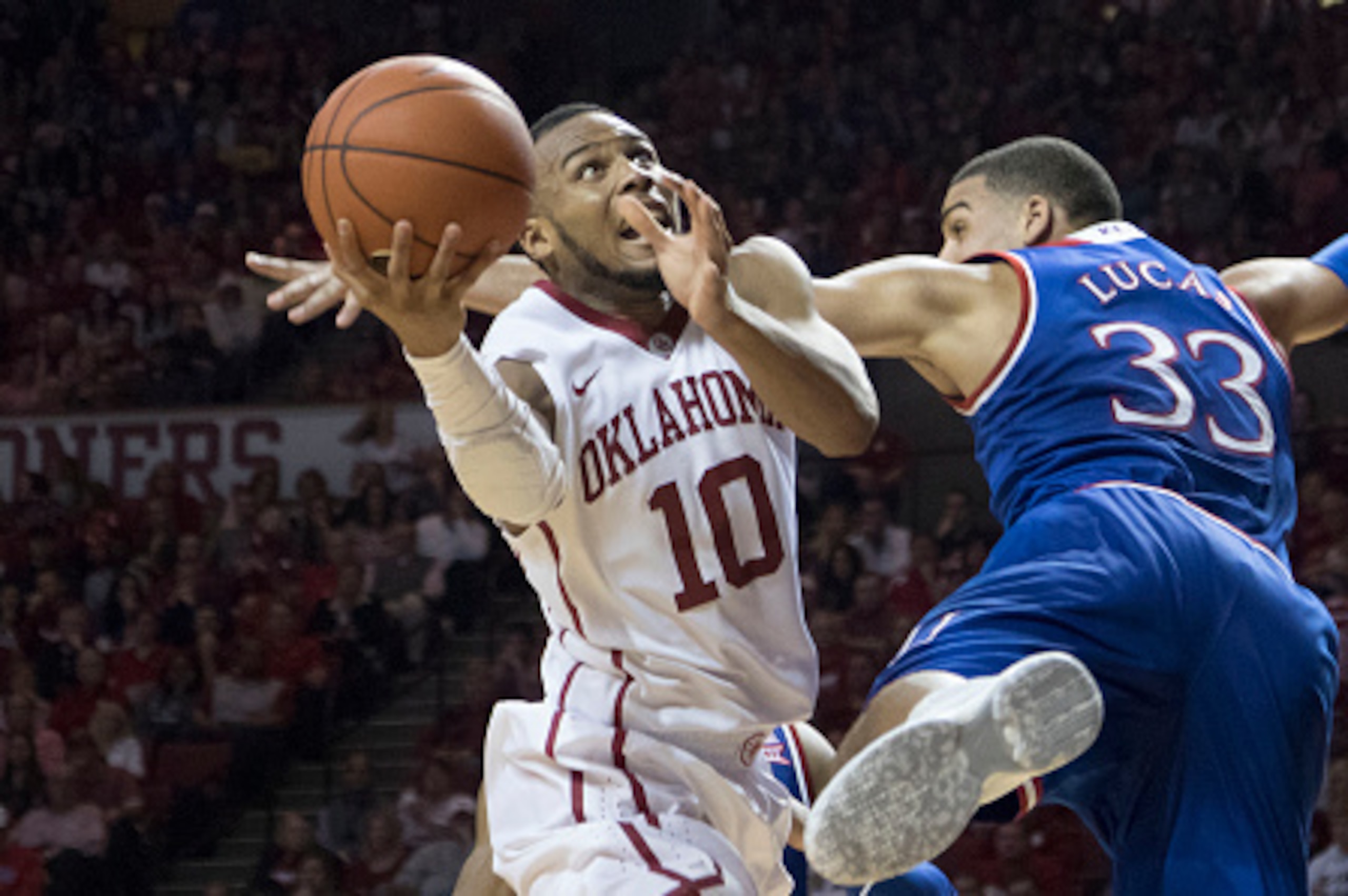 NORMAN, OK - February 13: Landen Lucas #33 of the Kansas Jayhawks applies pressure as Jordan Woodard #10 of the Oklahoma Sooners shoots during a NCAA college basketball game at the Lloyd Noble Center on February13, 2016 in Norman, Oklahoma. Kansas won 76-