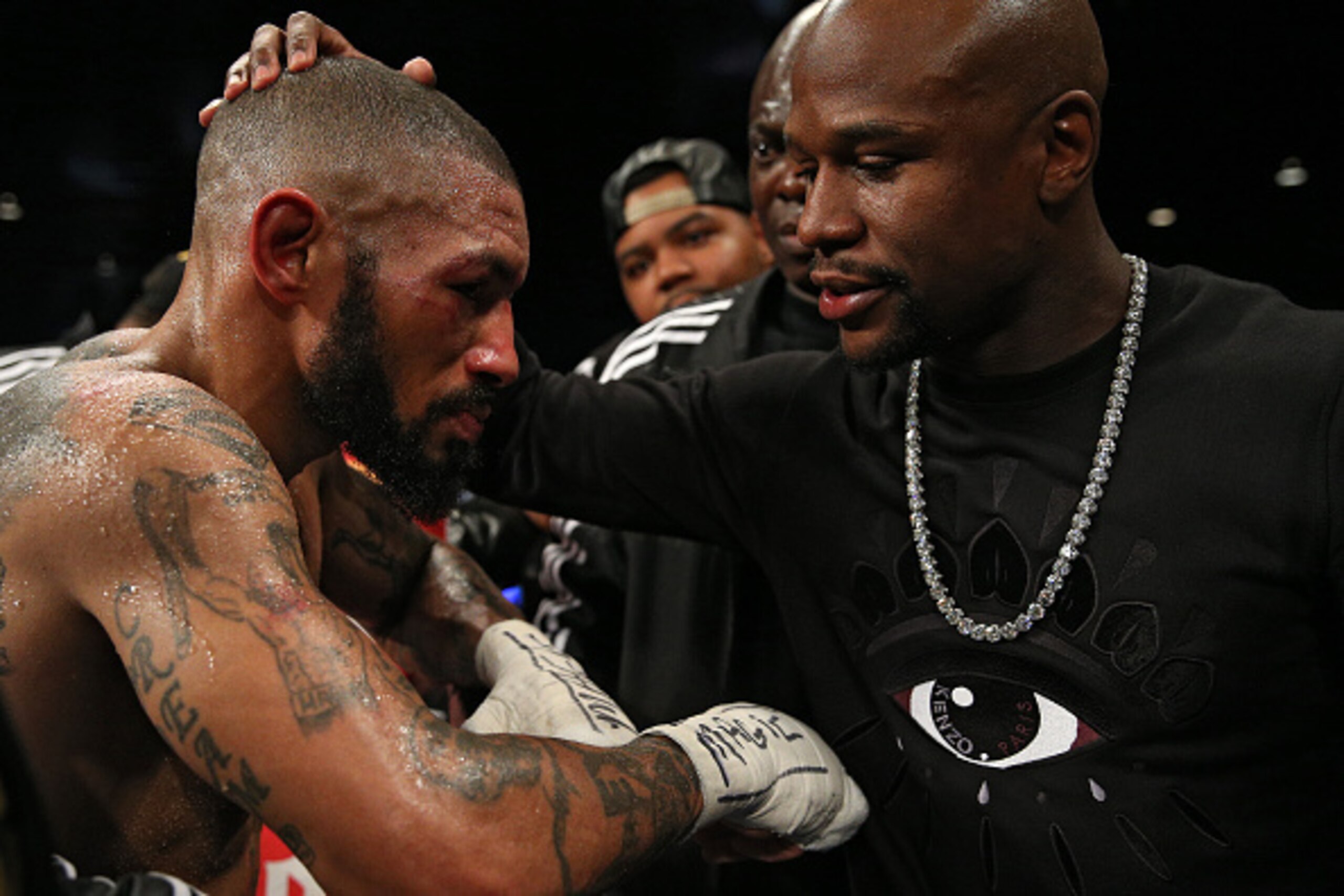 WASHINGTON, DC - APRIL 01: Ashley Theophane (L) is consoled by Floyd Mayweather after being defeated by TKO in the ninth round by Adrien Broner (not pictured) in their super lightweight championship bout at the DC Armory on April 1, 2016 in Washington, DC