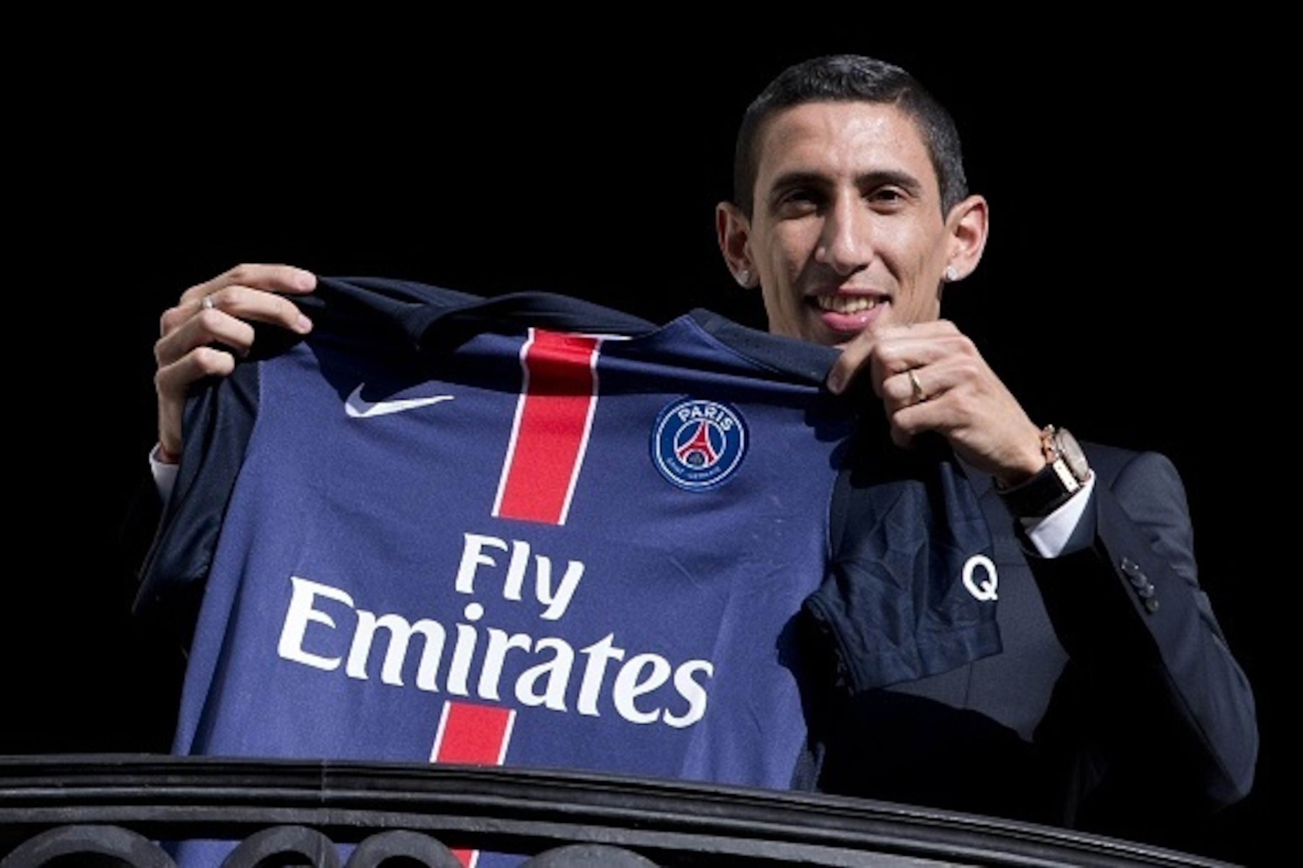 Paris Saint-Germain's (PSG) new Argentinian midfielder Angel Di Maria poses with his PSG jersey on a balcony during his official presentation in Paris on August 6, 2015. Paris Saint-Germain completed the signing of Di Maria from Manchester United on a fou