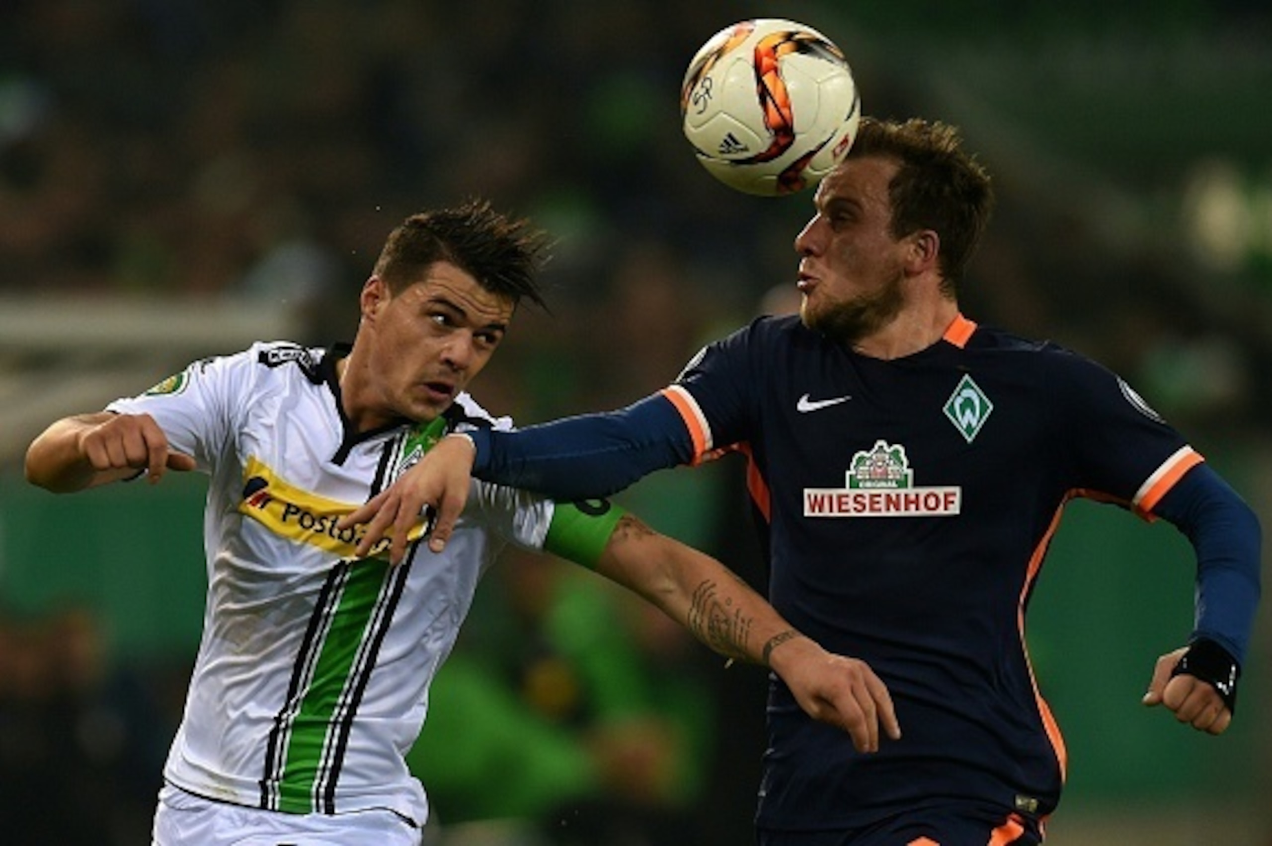 Moenchengladbach's Swiss midfielder Granit Xhaka and Bremen's midfielder Philipp Bargfrede vie for the ball during the German Trophy (DFB-Pokal) round of sixteen football match Borussia Moenchengladbach vs SV Werder Bremen in Moenchengladbach, western Ger