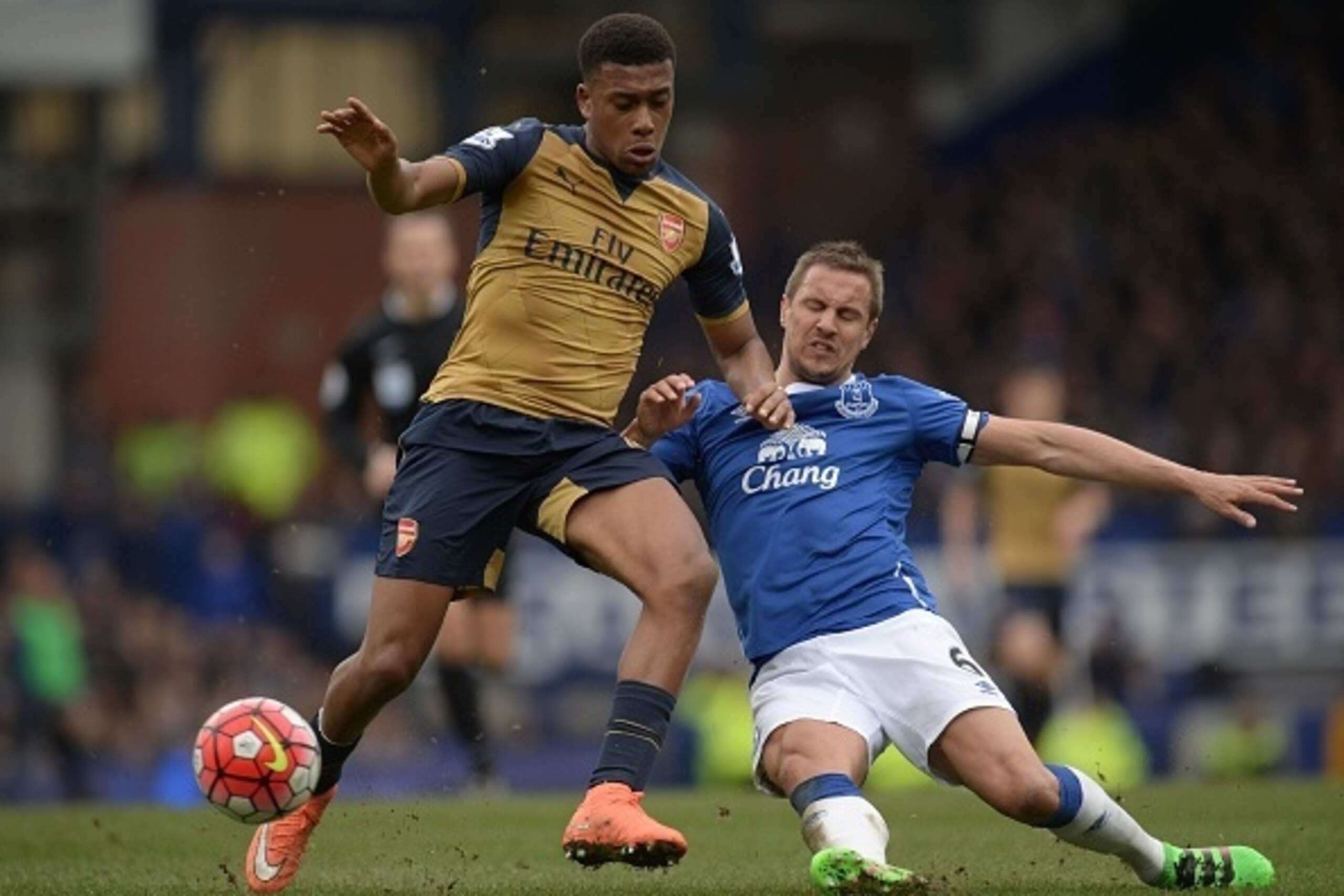 Arsenal's Nigerian striker Alex Iwobi (L) vies with Everton's English defender Phil Jagielka during the English Premier League football match between Everton and Arsenal at Goodison Park in Liverpool, north west England on March 19, 2016. / AFP / OLI SCAR