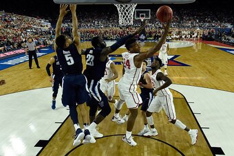 HOUSTON, TEXAS - APRIL 02:  Buddy Hield #24 of the Oklahoma Sooners shoots the ball against Daniel Ochefu #23 of the Villanova Wildcats and Phil Booth #5 in the first half during the NCAA Men's Final Four Semifinal at NRG Stadium on April 2, 2016 in Houst