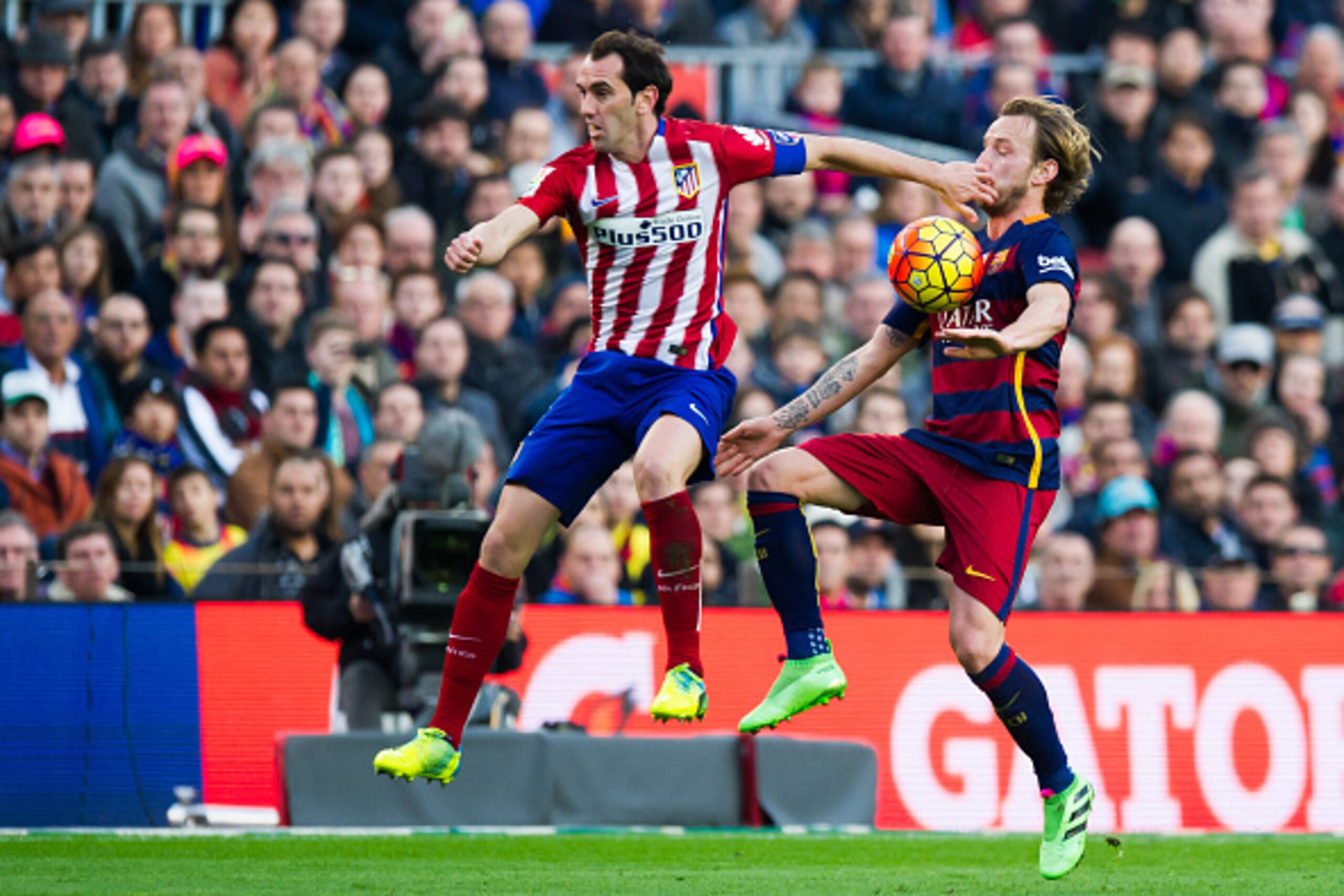 BARCELONA, SPAIN - JANUARY 30: Diego Godin (L) of Club Atletico de Madrid and Ivan Rakitic of FC Barcelona fight for the ball during the La Liga match between FC Barcelona and Club Atletico de Madrid at Camp Nou on January 30, 2016 in Barcelona, Spain. (P