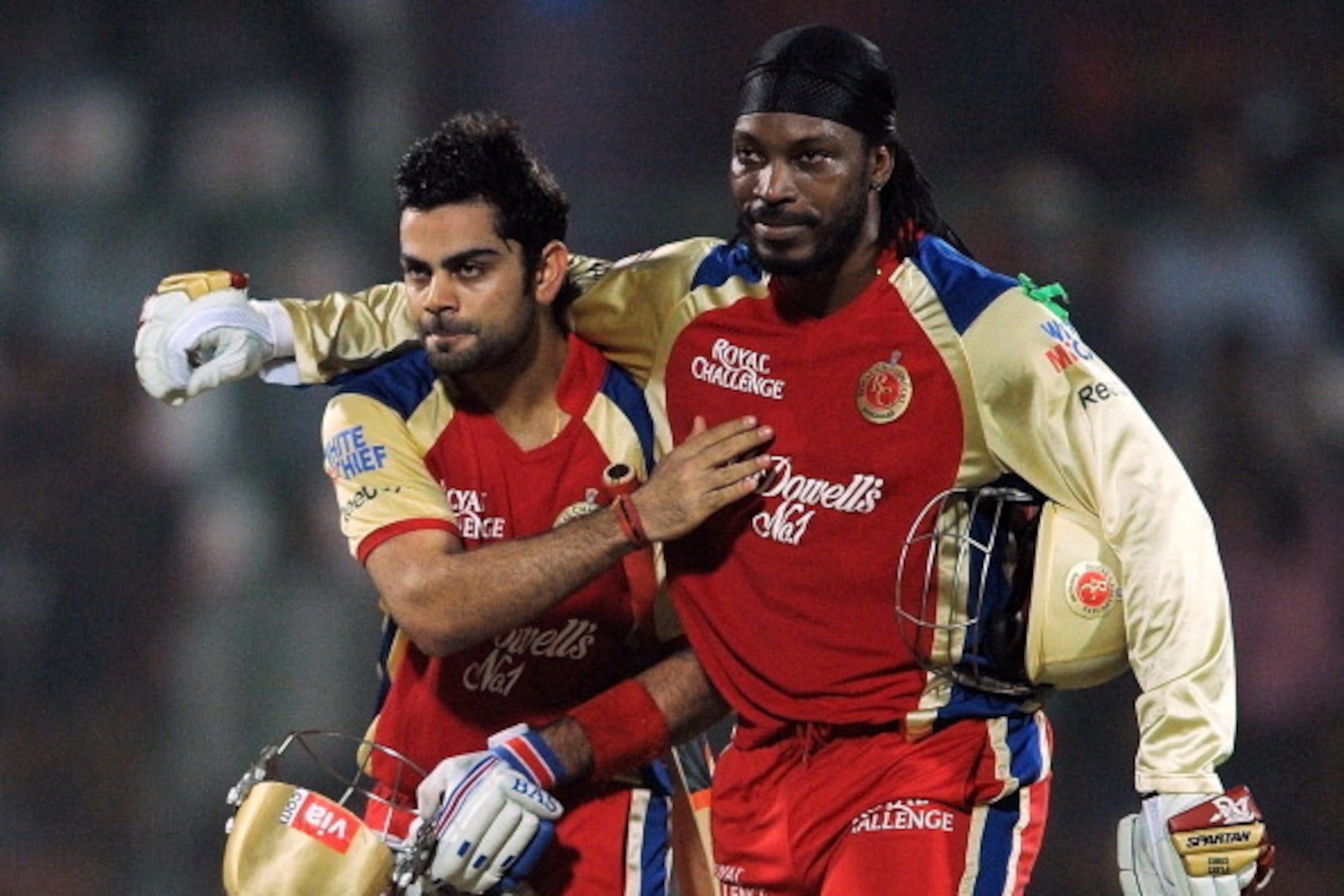 Royal Challengers Bangalore batsman Chris Gayle (R) hugs teammate Virat Kohli after the end of their innings during the IPL Twenty20 cricket match between Delhi Daredevils and Royal Challengers Bangalore at the Feroz Shah Kotla stadium in New Delhi on May